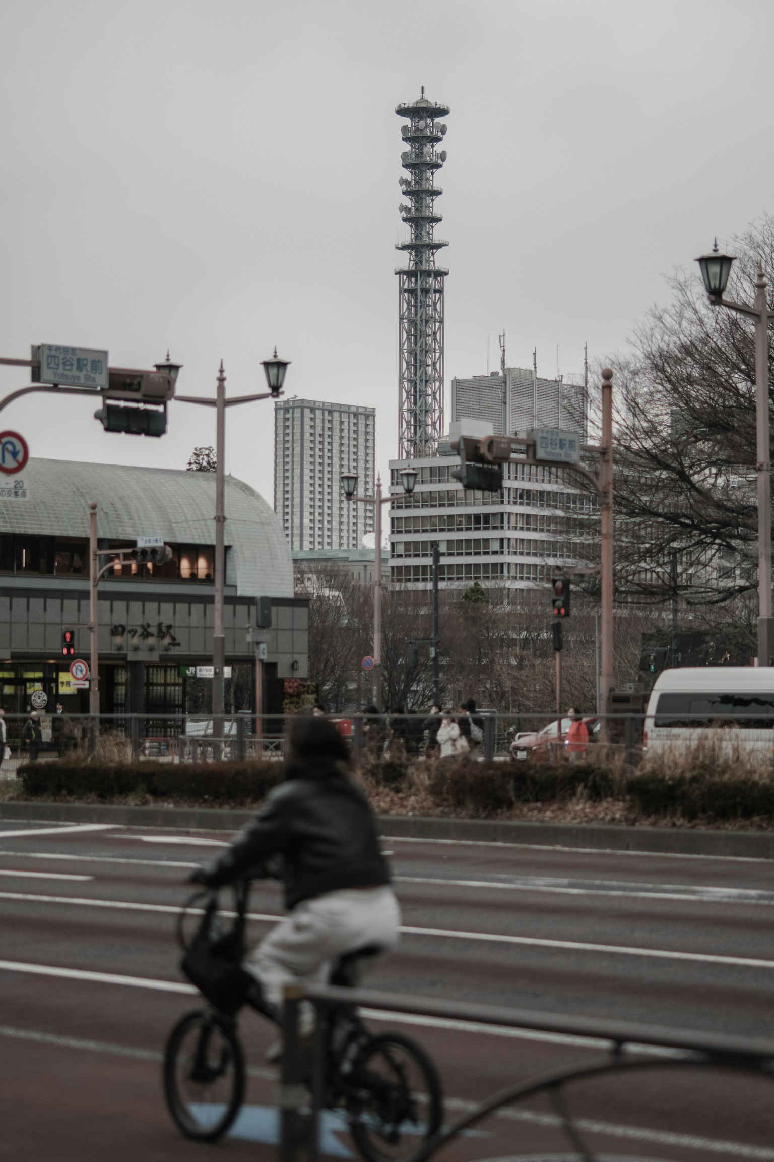Una persona che pedala con uno skyline urbano sullo sfondo in una giornata nuvolosa