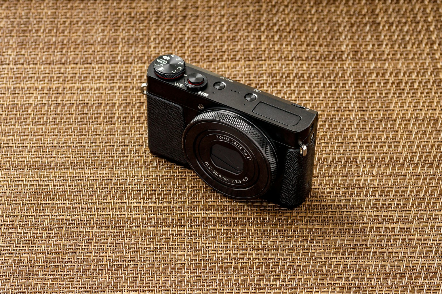 Una cámara compacta negra colocada sobre un fondo texturizado