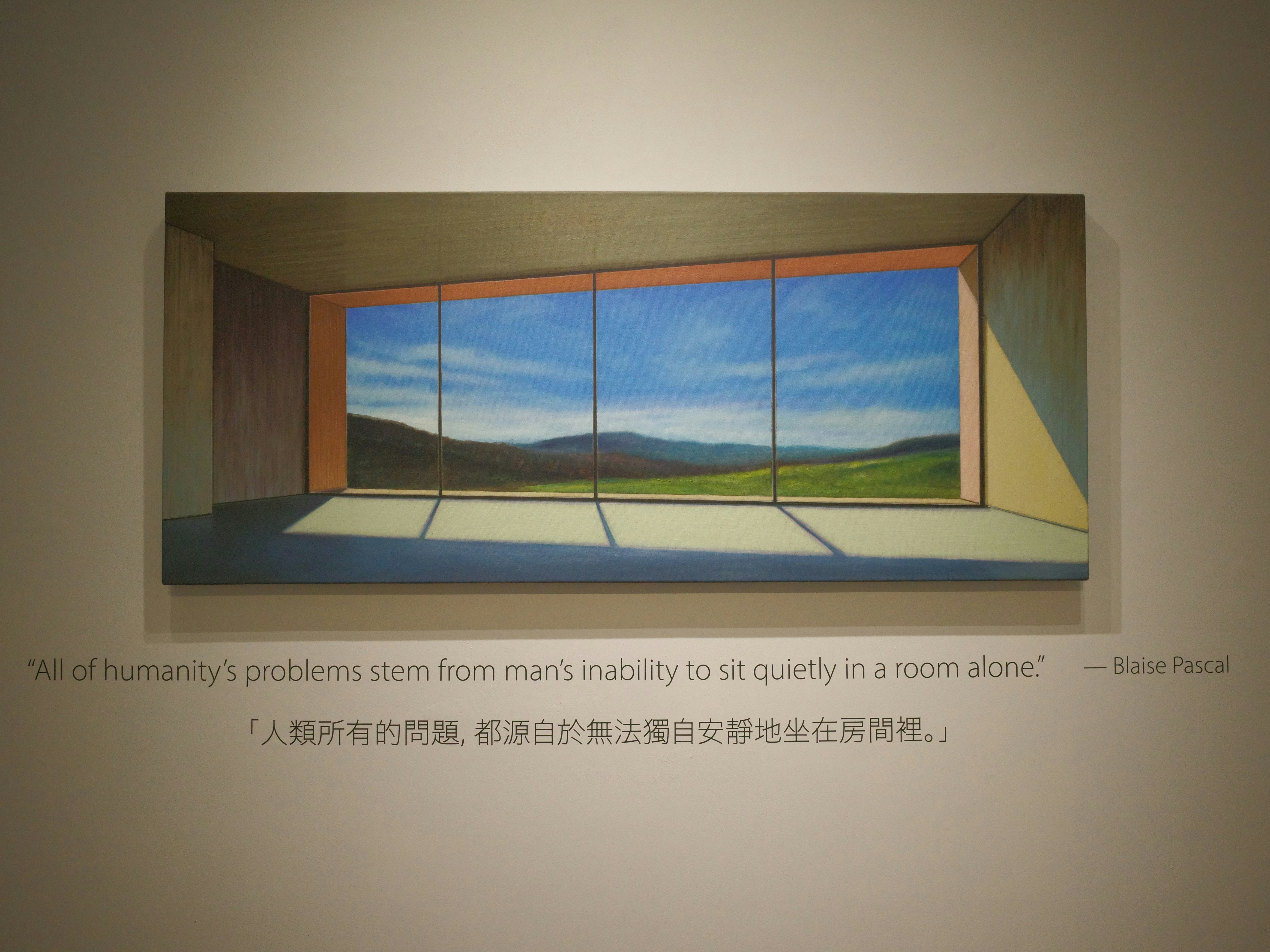 窓のある室内で風景が描かれた大きな絵画