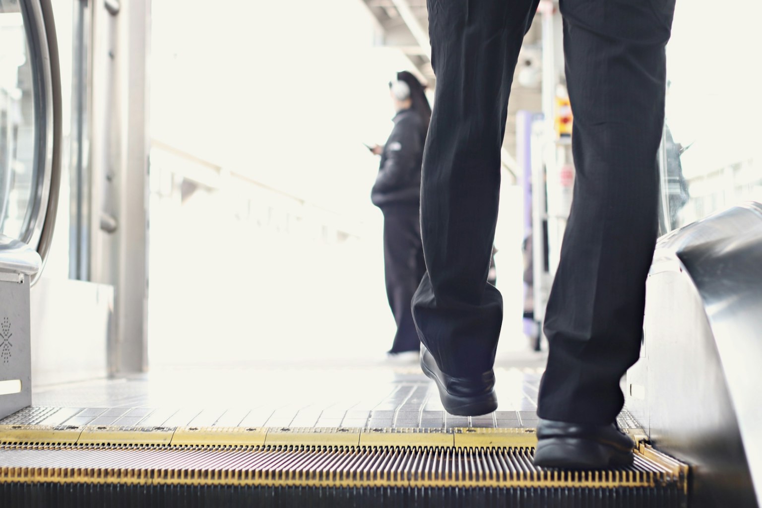 Des pieds d'une personne montant sur un quai de train