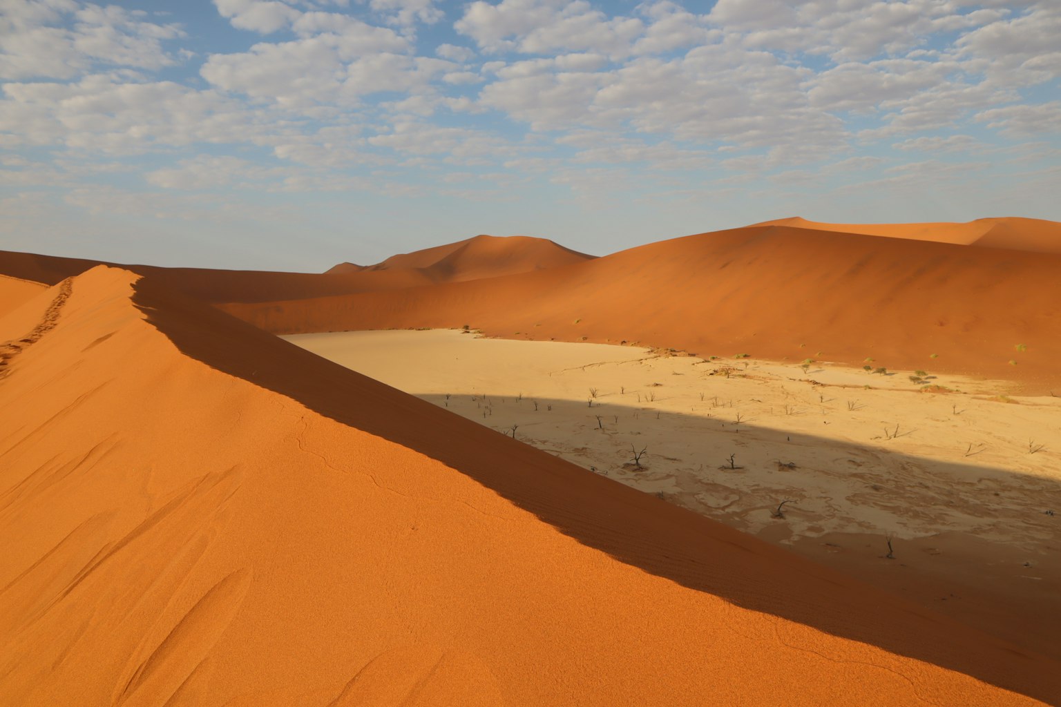Dune di sabbia arancione e pianura di sabbia gialla nel deserto del Sahara
