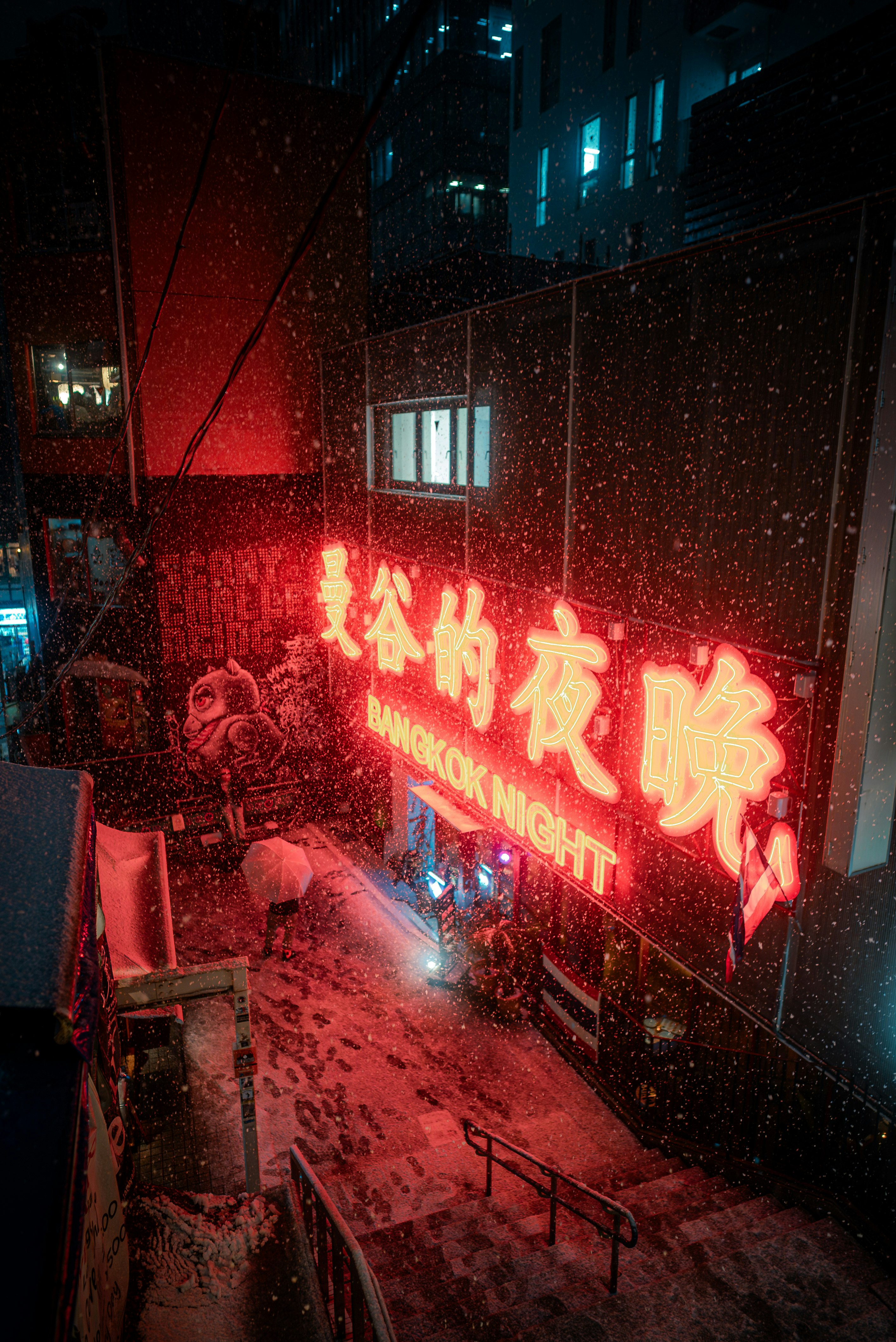 Enseigne « Bangkok Night » illuminée par des néons rouges dans une ruelle nocturne