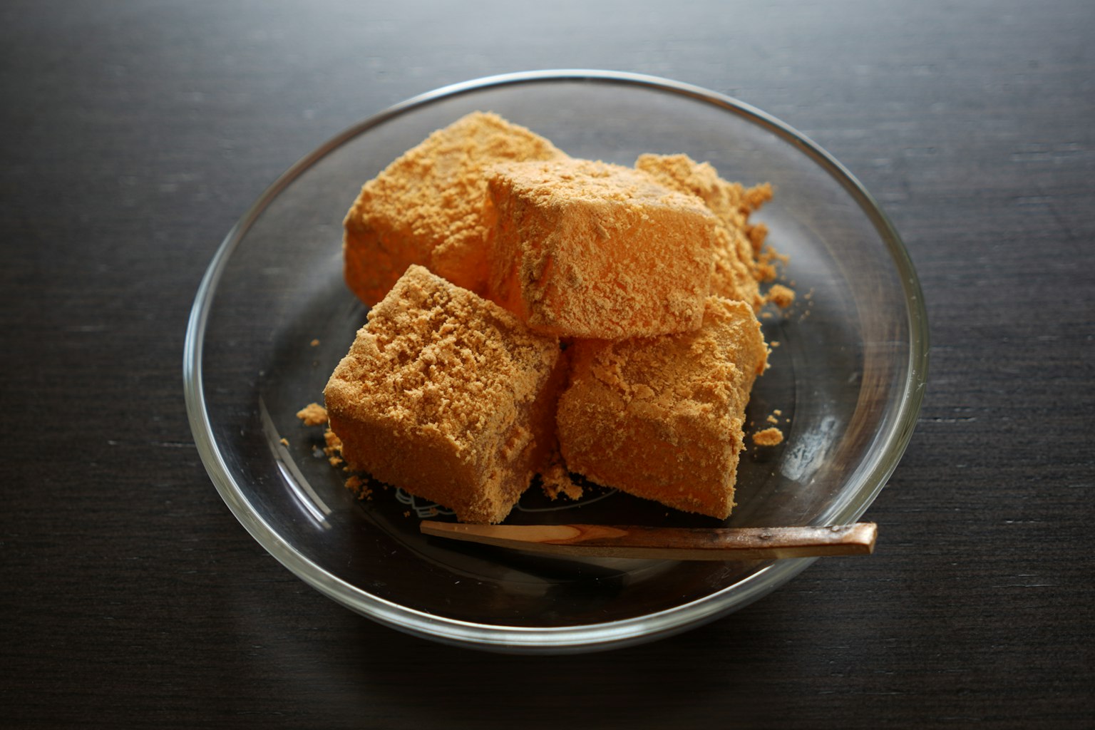 Blocchi di tofu giallo su un piatto di vetro