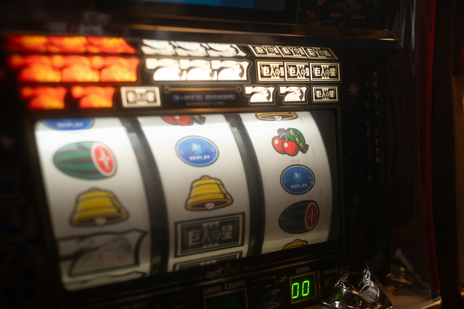 Nahaufnahme eines Spielautomaten mit Symbolen wie Glocken, Wassermelonen und Kirschen