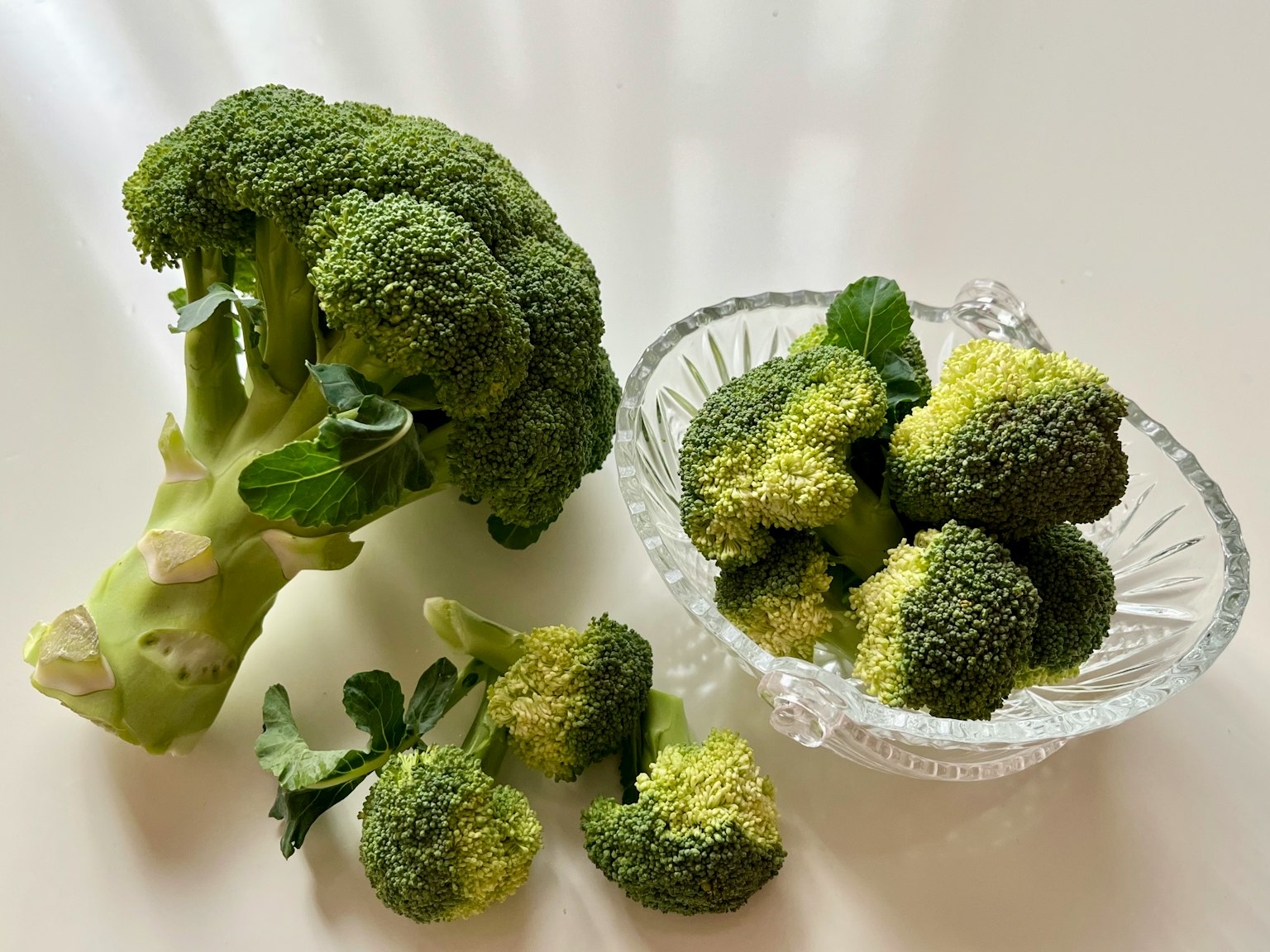 Un mazzo di broccoli freschi con piccoli ciuffi di broccolo in una ciotola di vetro