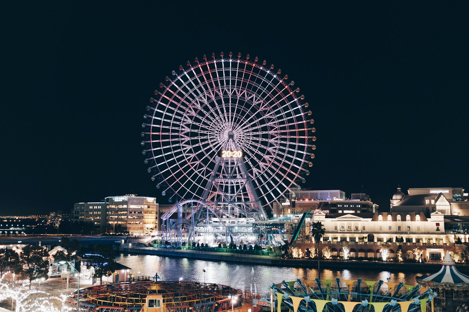 Beleuchtetes Riesenrad bei Nacht mit bunten Lichtern