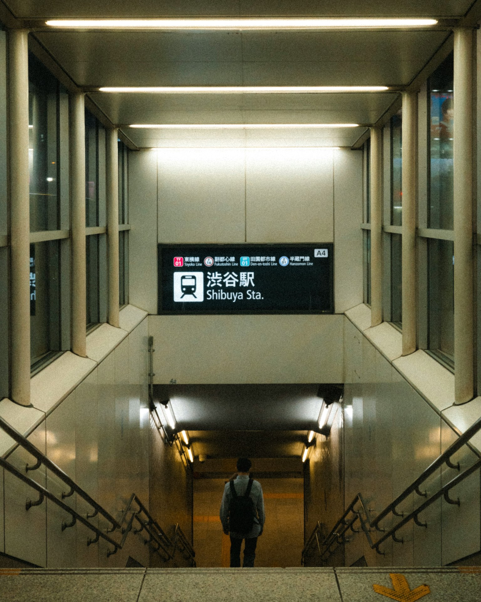 渋谷駅の階段を下る人の写真 明るい照明と現代的なデザイン