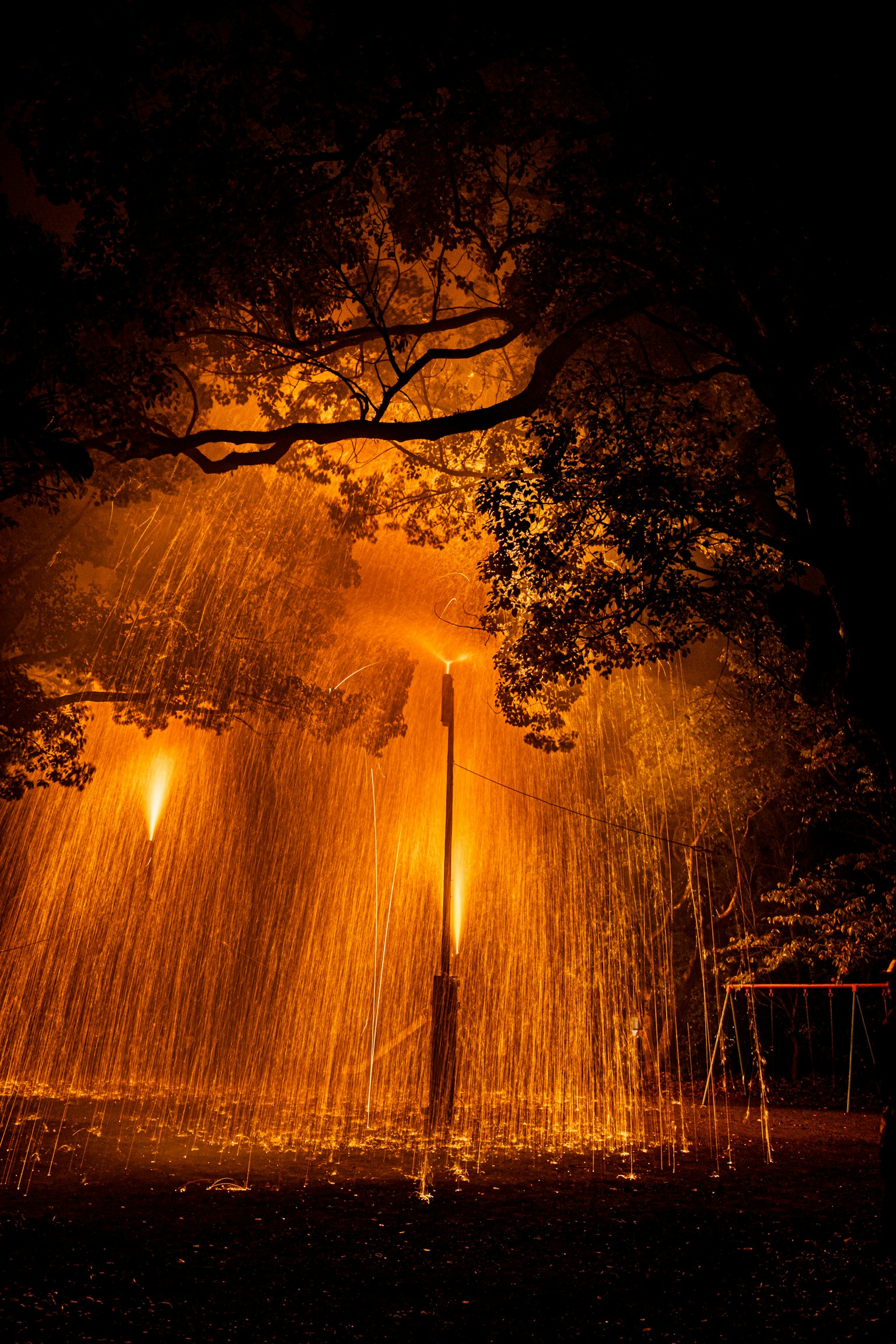 Fuente iluminada por luz naranja en un parque por la noche