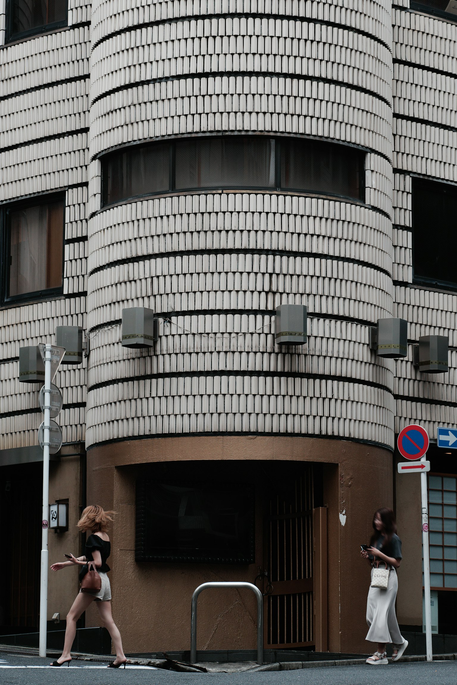 两名女性在独特的圆柱形建筑前走