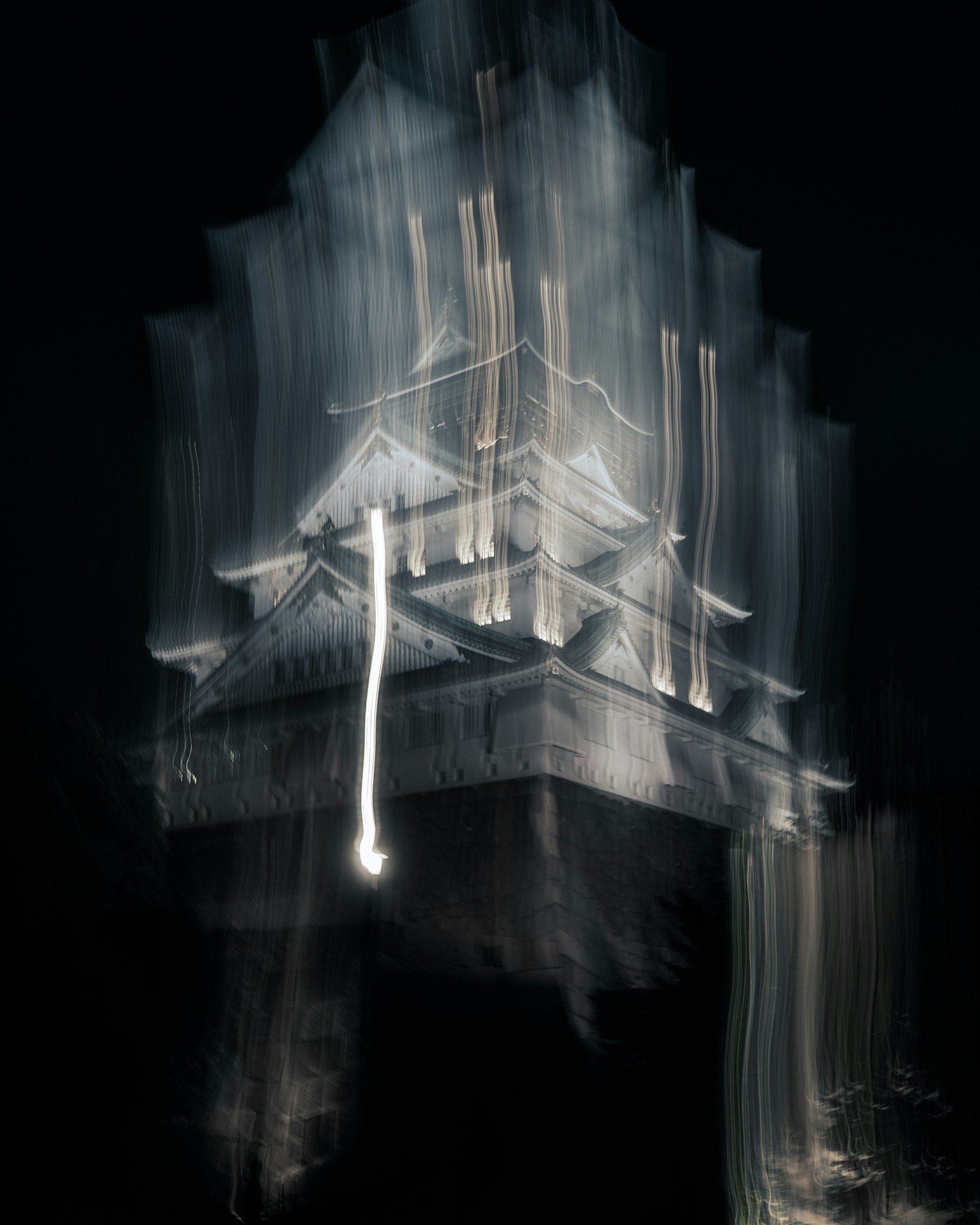 Vista notturna sfocata del castello di Osaka illuminato da luci