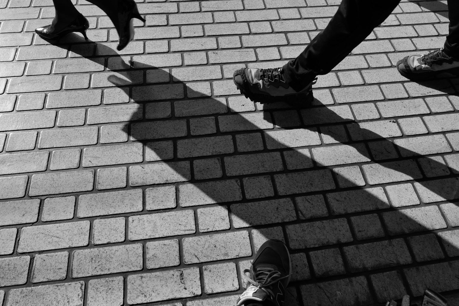Scena di strada in bianco e nero che mostra le ombre di persone che camminano