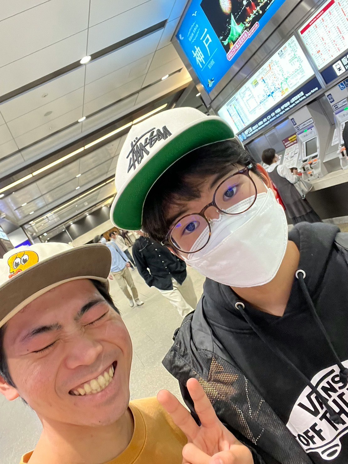 火车站里戴帽戴口罩的年轻人微笑摆姿势
