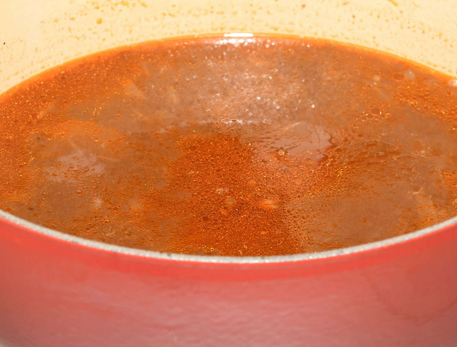 Sup pedas yang mendidih dalam panci merah