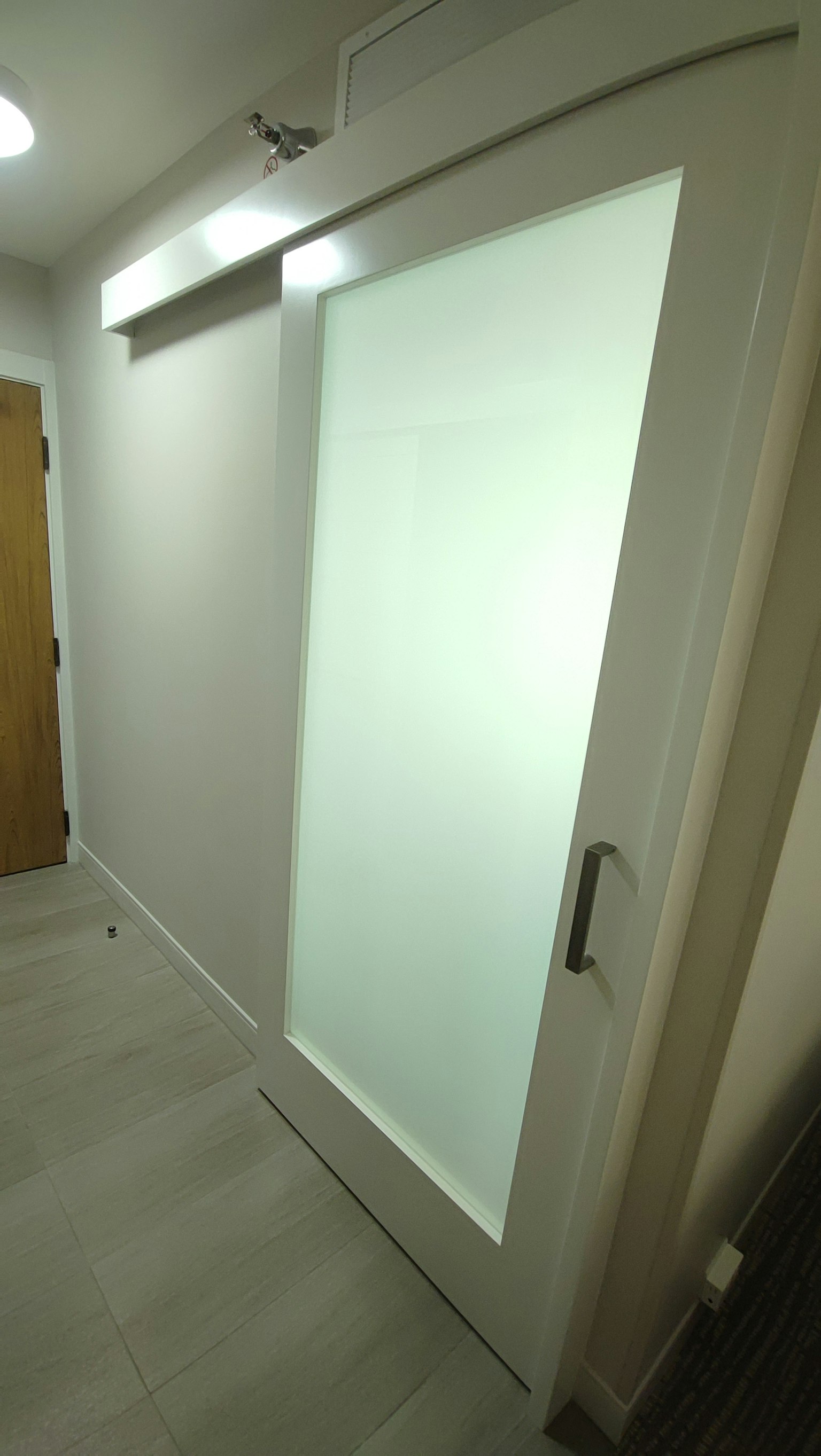 Corridoio moderno con porta scorrevole in vetro bianco