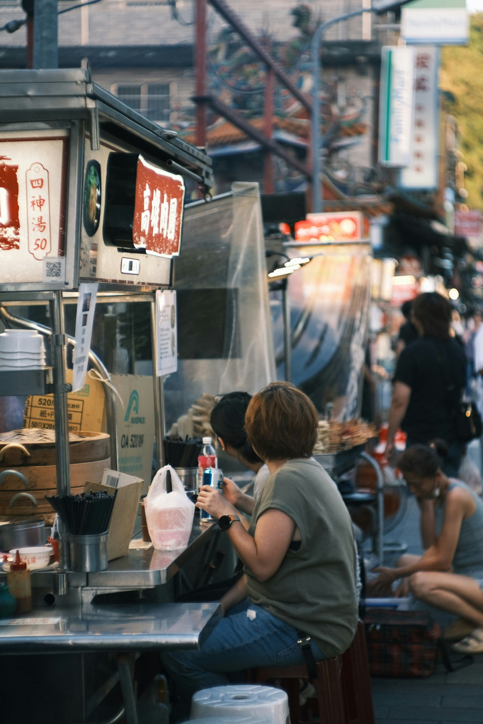 屋台の食べ物を楽しむ人々がいる賑やかな市場の風景