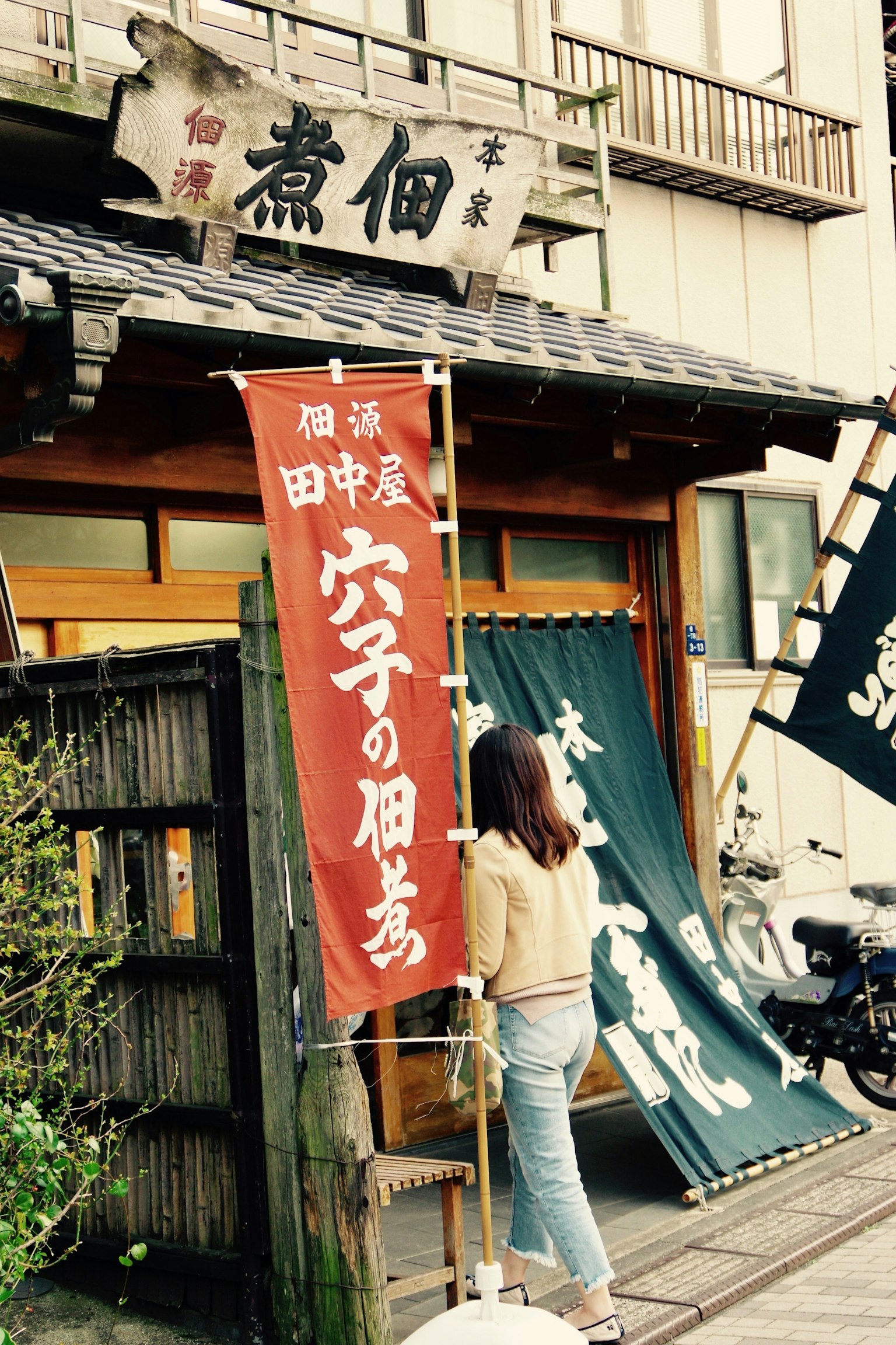 傳統日本餐廳外觀 女性注視著紅色橫幅