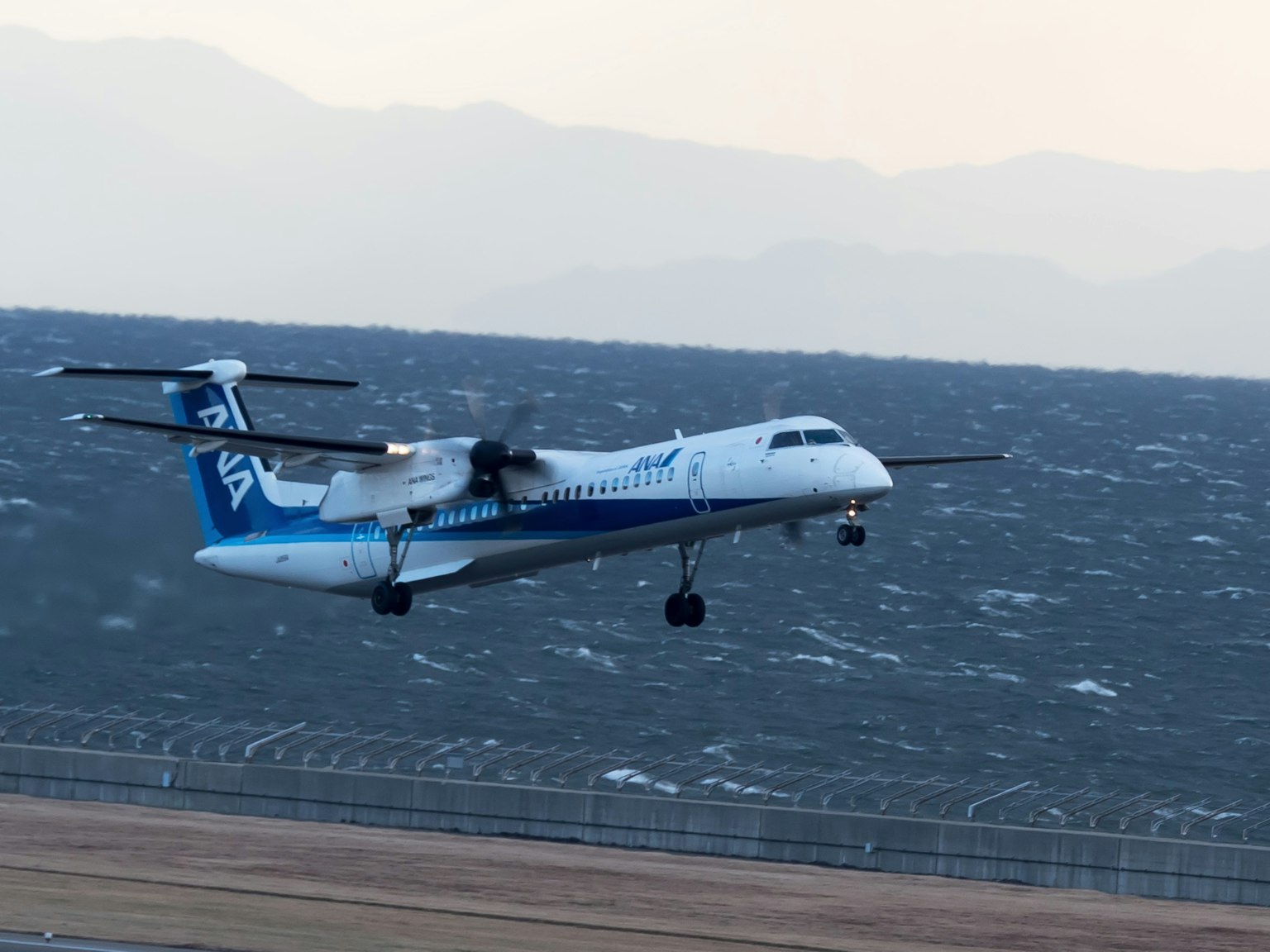 Ein Flugzeug landet mit Bergen im Hintergrund