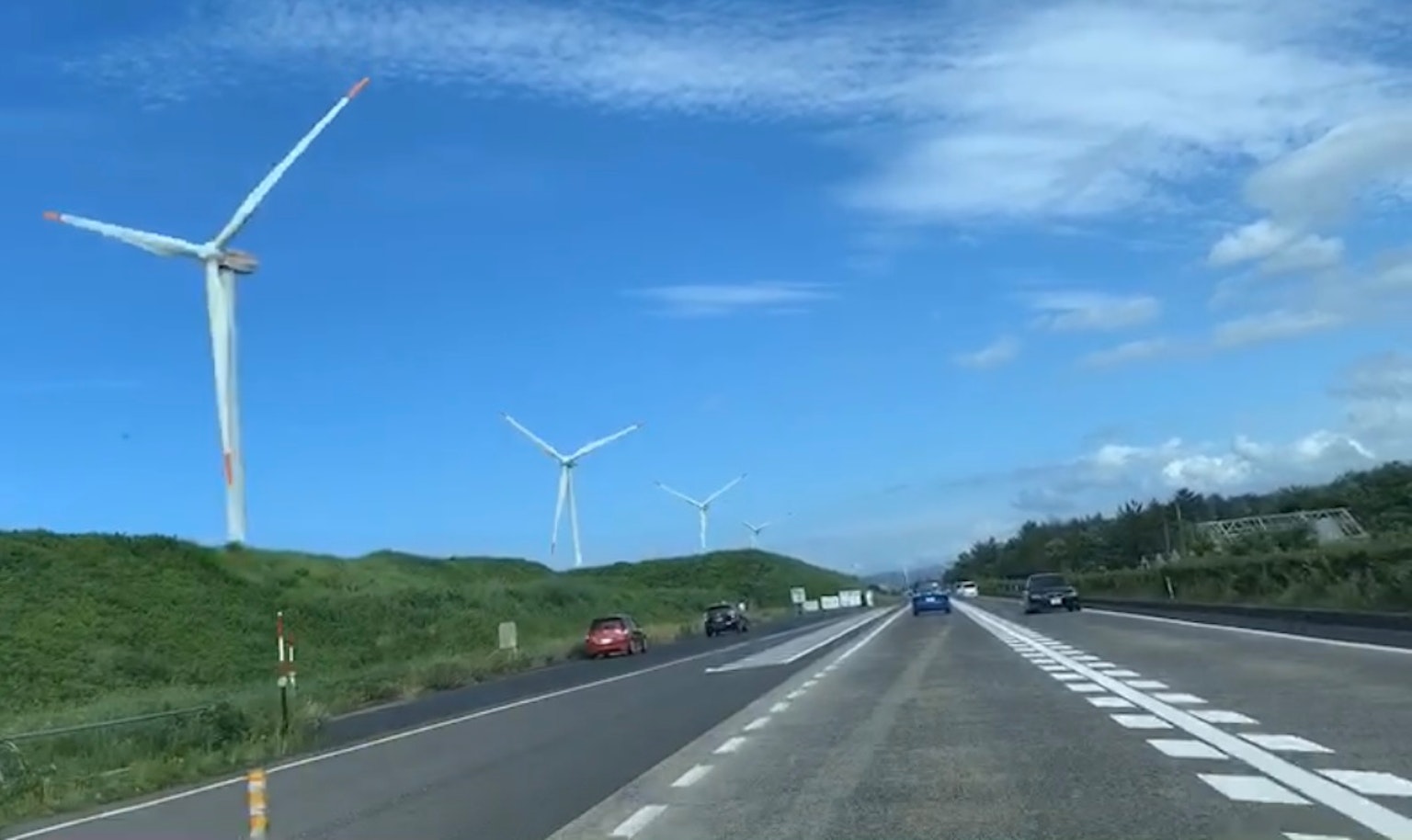 Autoroute avec des éoliennes sous un ciel bleu