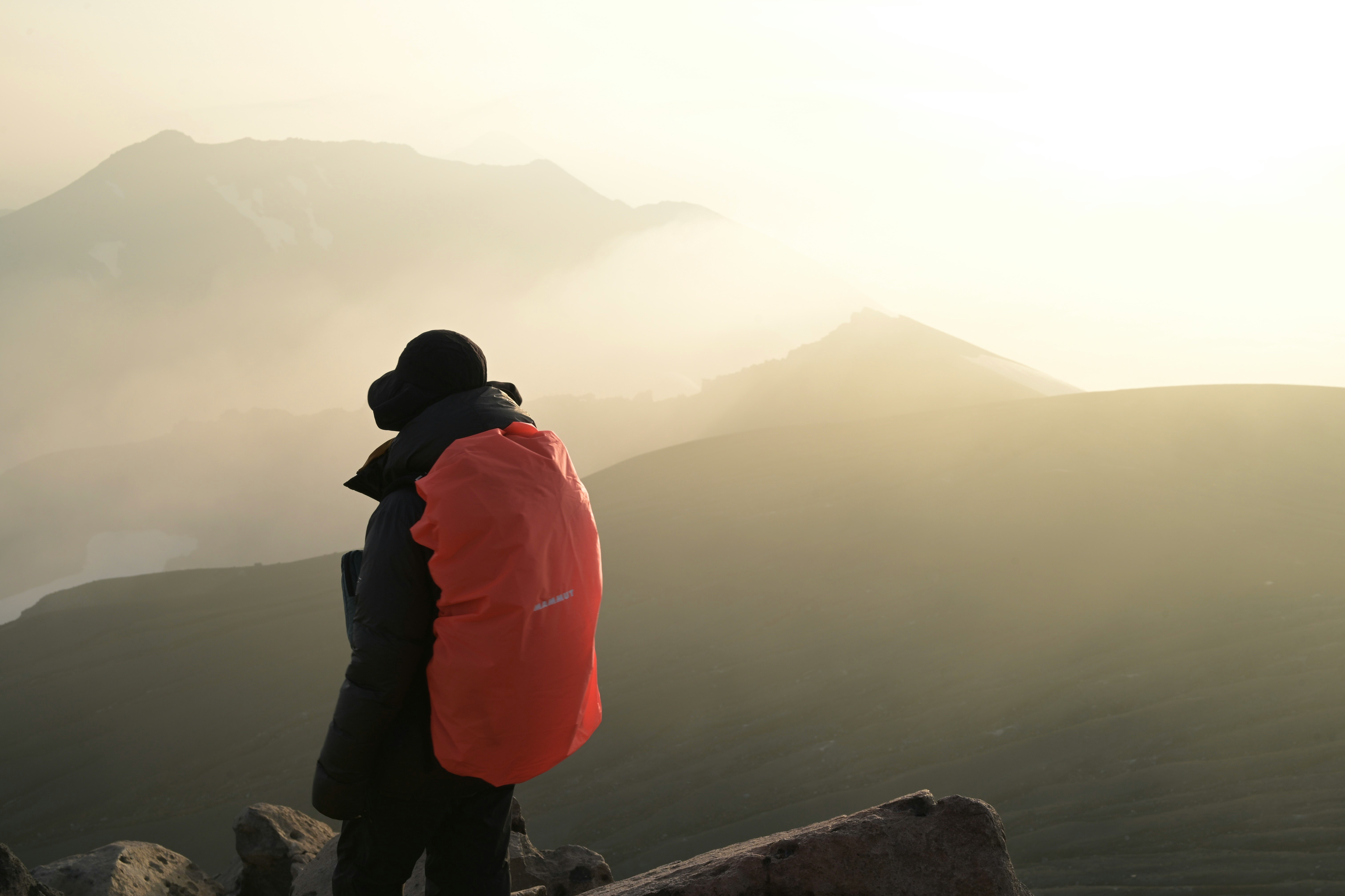 霧の山並みに向かう登山者の後ろ姿
