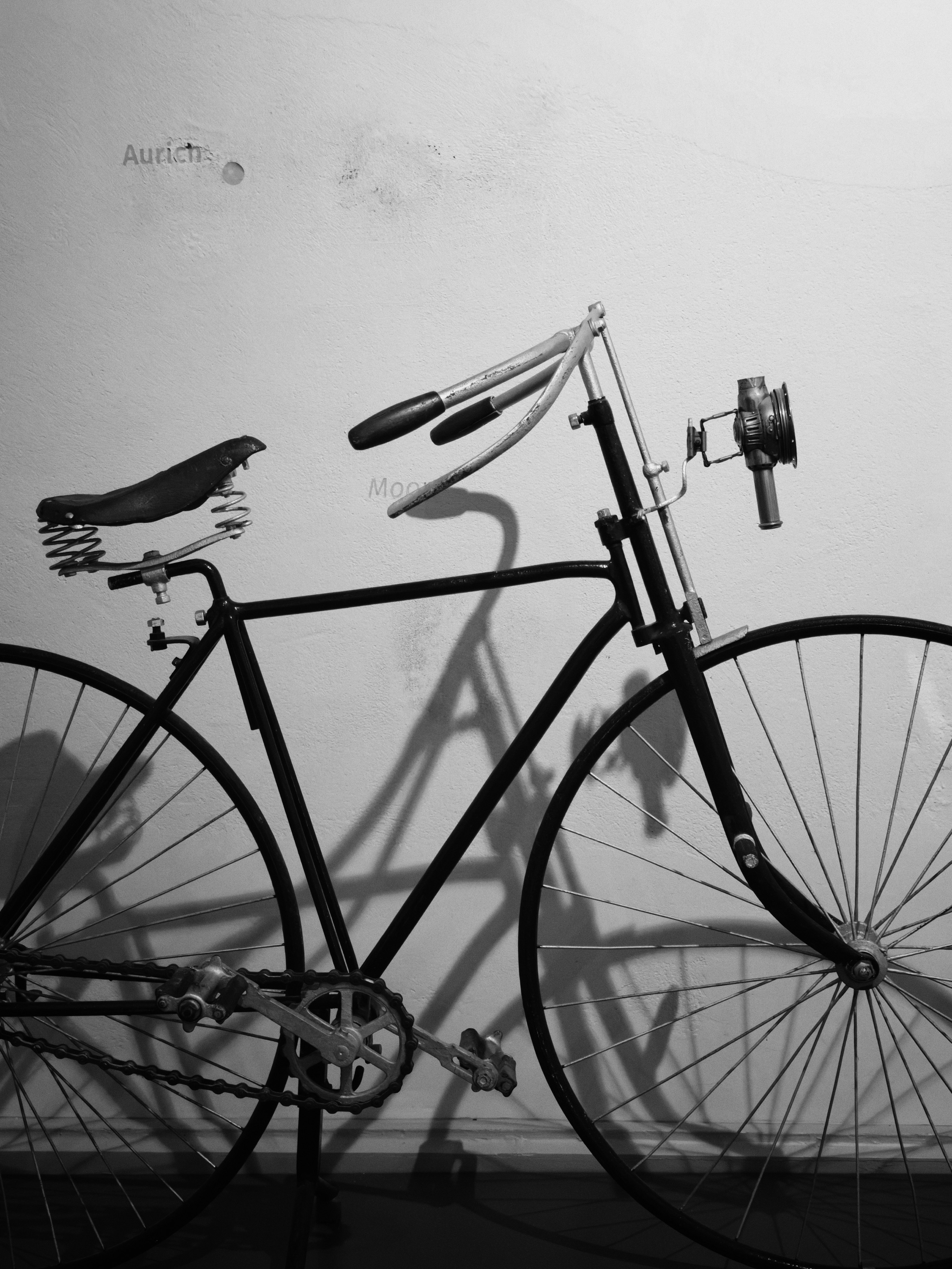 monochrome street scene with a bicycle frame and its shadow on a wall
