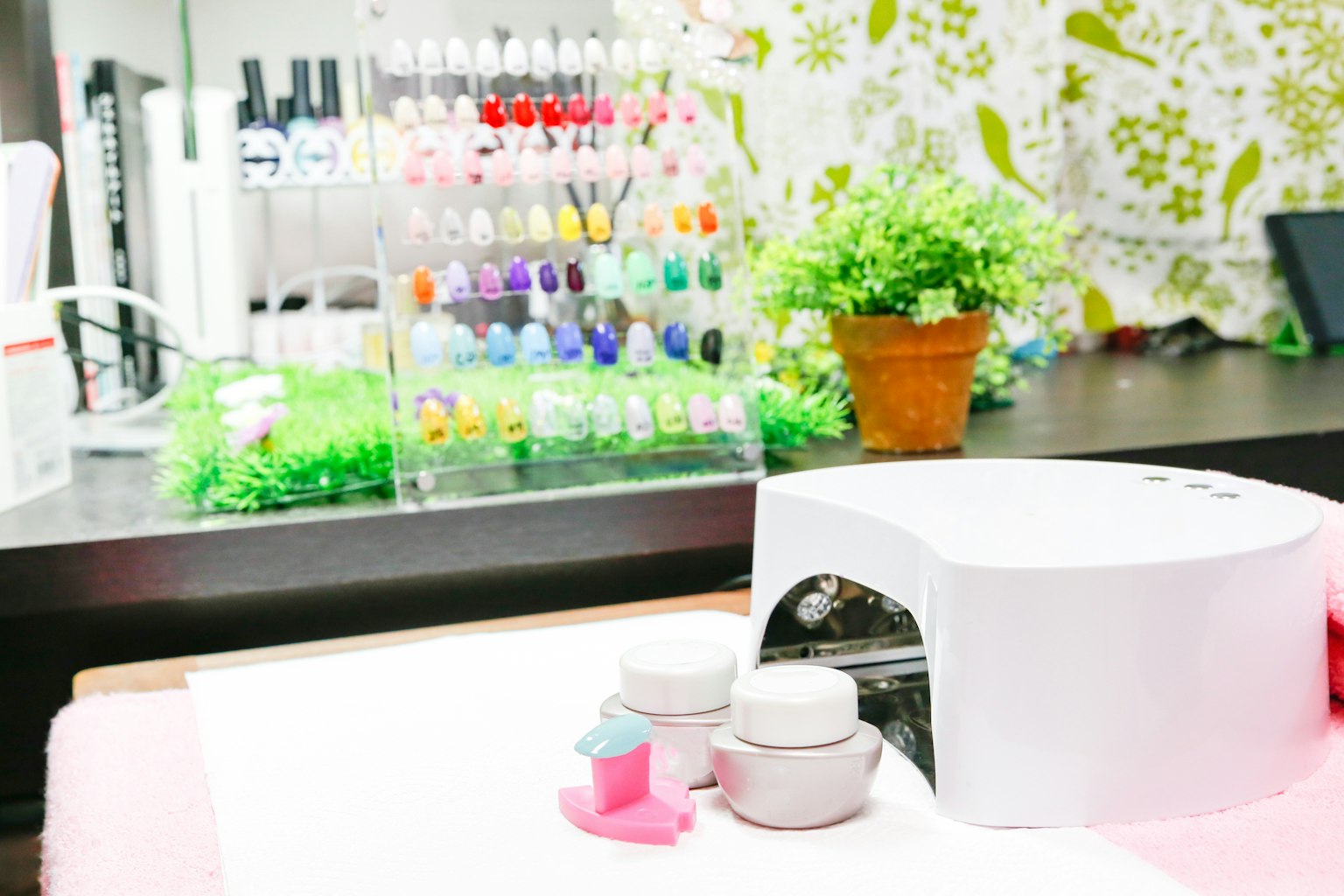 Interior de un salón de uñas con una colorida exhibición de esmaltes y una estación de manicura