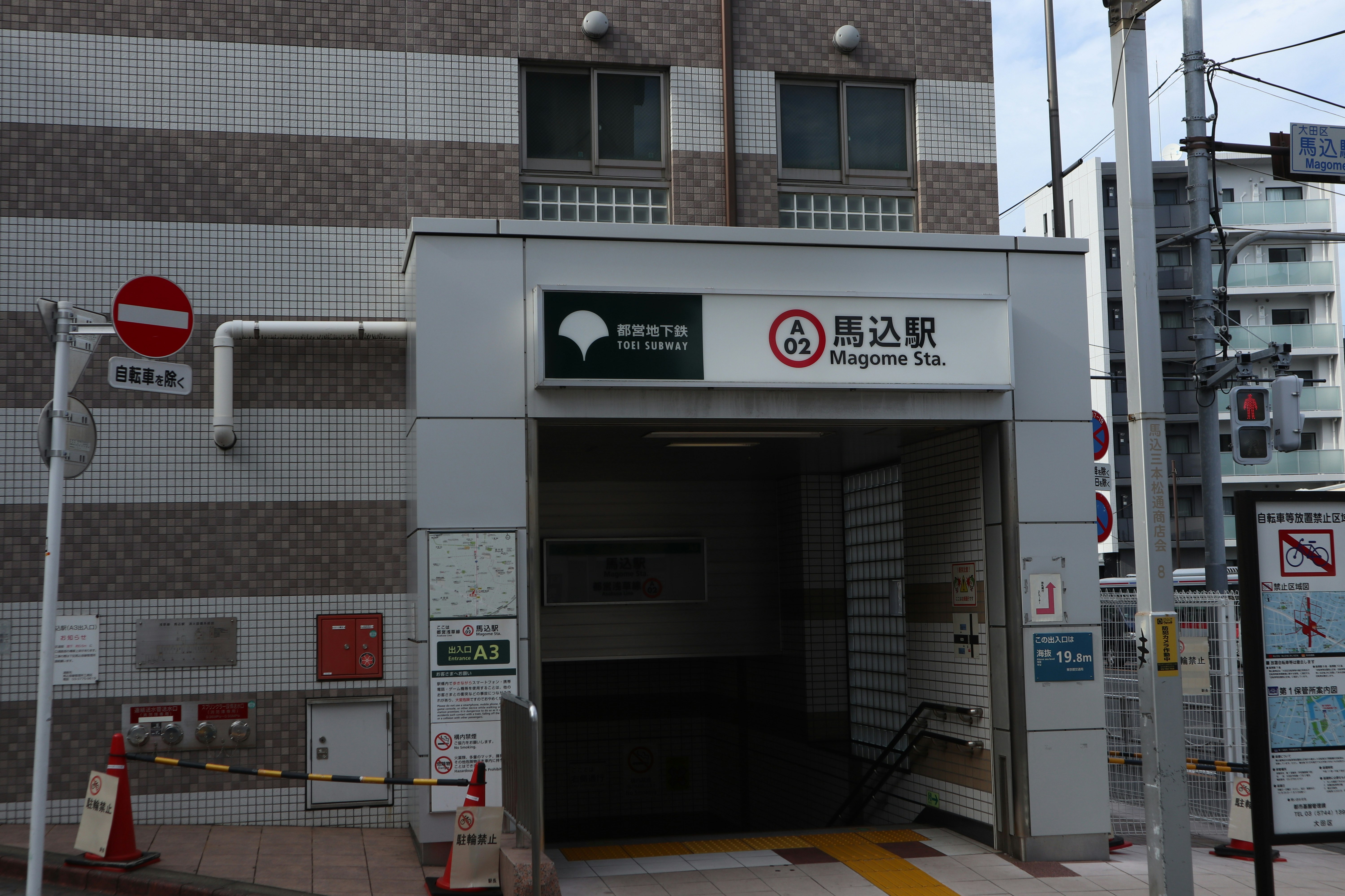 Cổng soát vé ở ga Magome dưới đường ray trên cao kèm biển chỉ dẫn