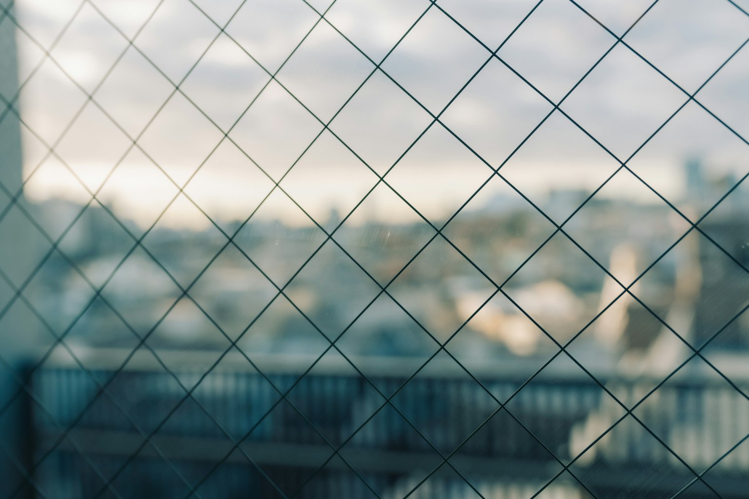 Vue floue d'un paysage urbain à travers une clôture en treillis