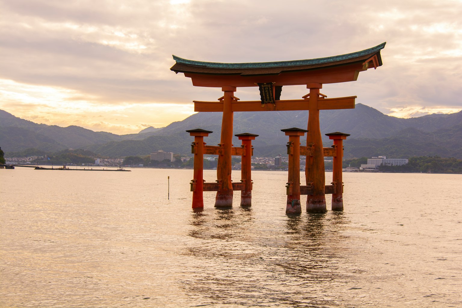 Torii im Wasser mit Bergen im Hintergrund
