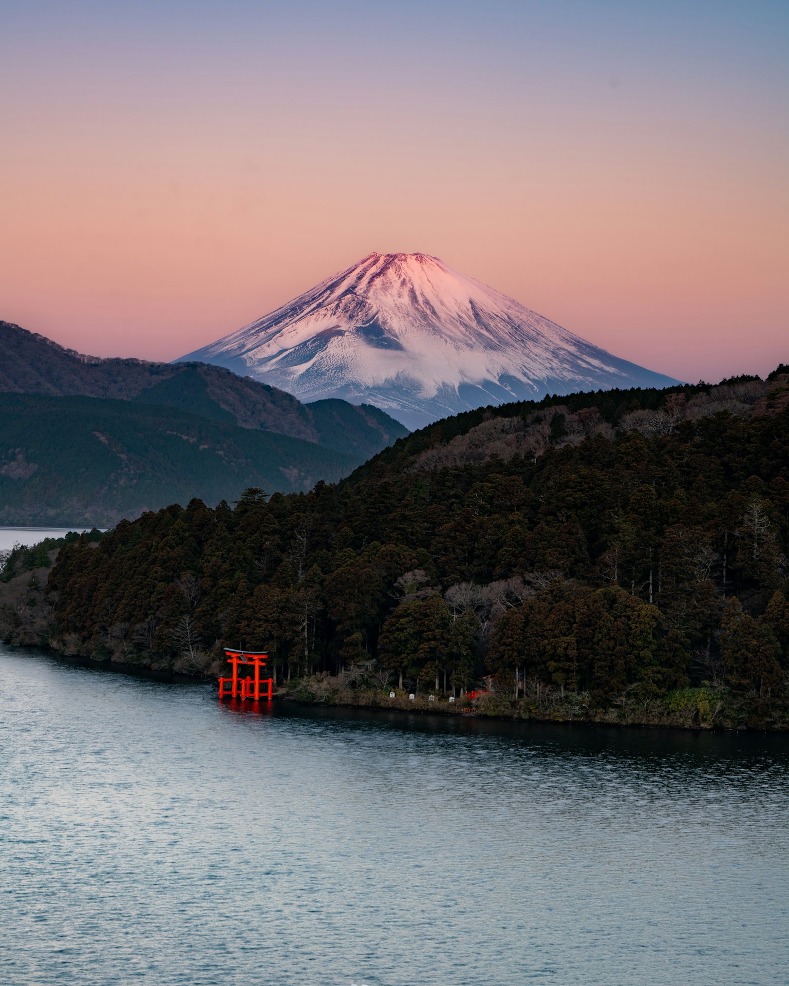 Scenic view of Mount Fuji with a red torii gate by the lake