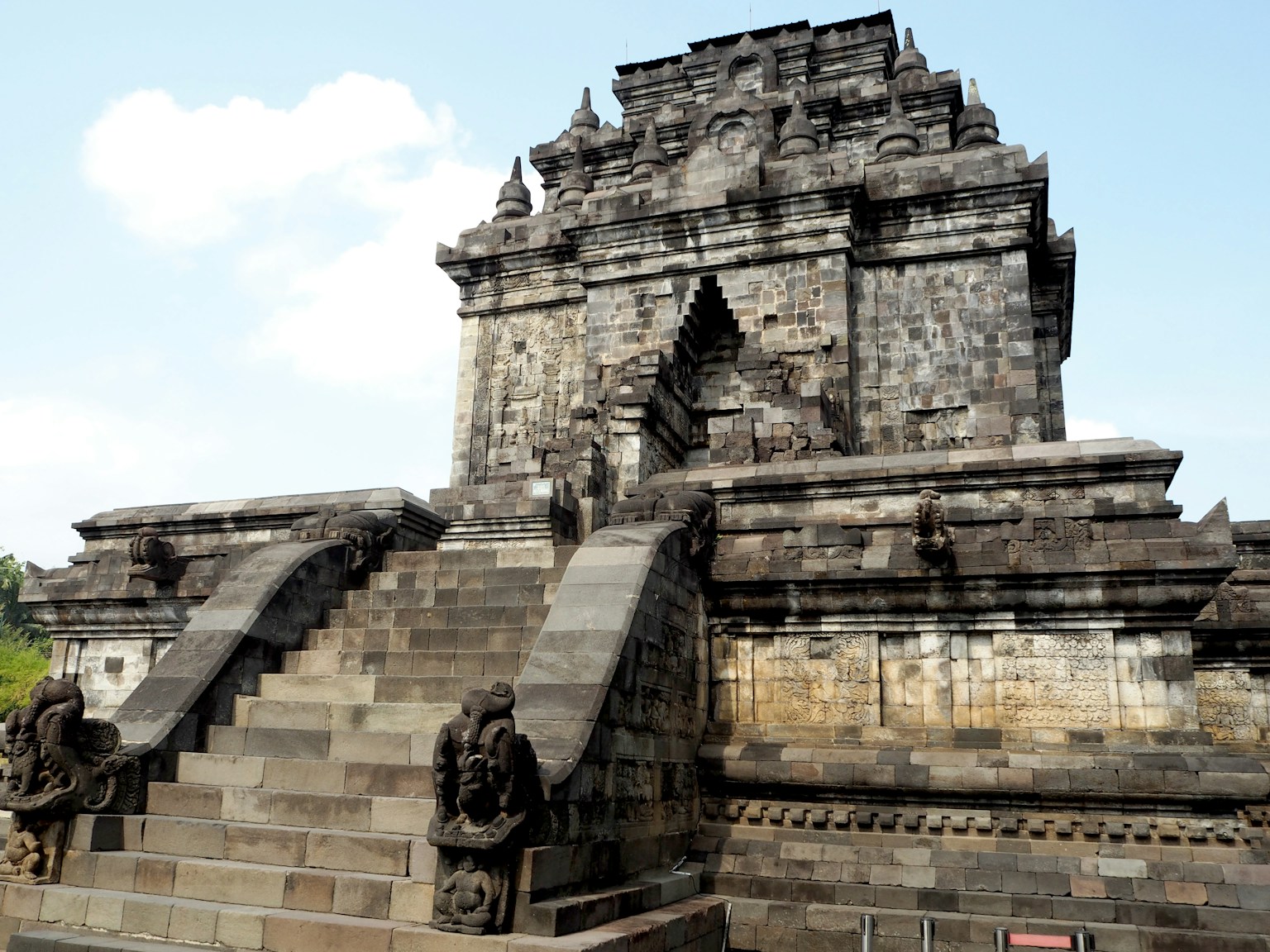 Stone temple structure with stairs and guardian statues