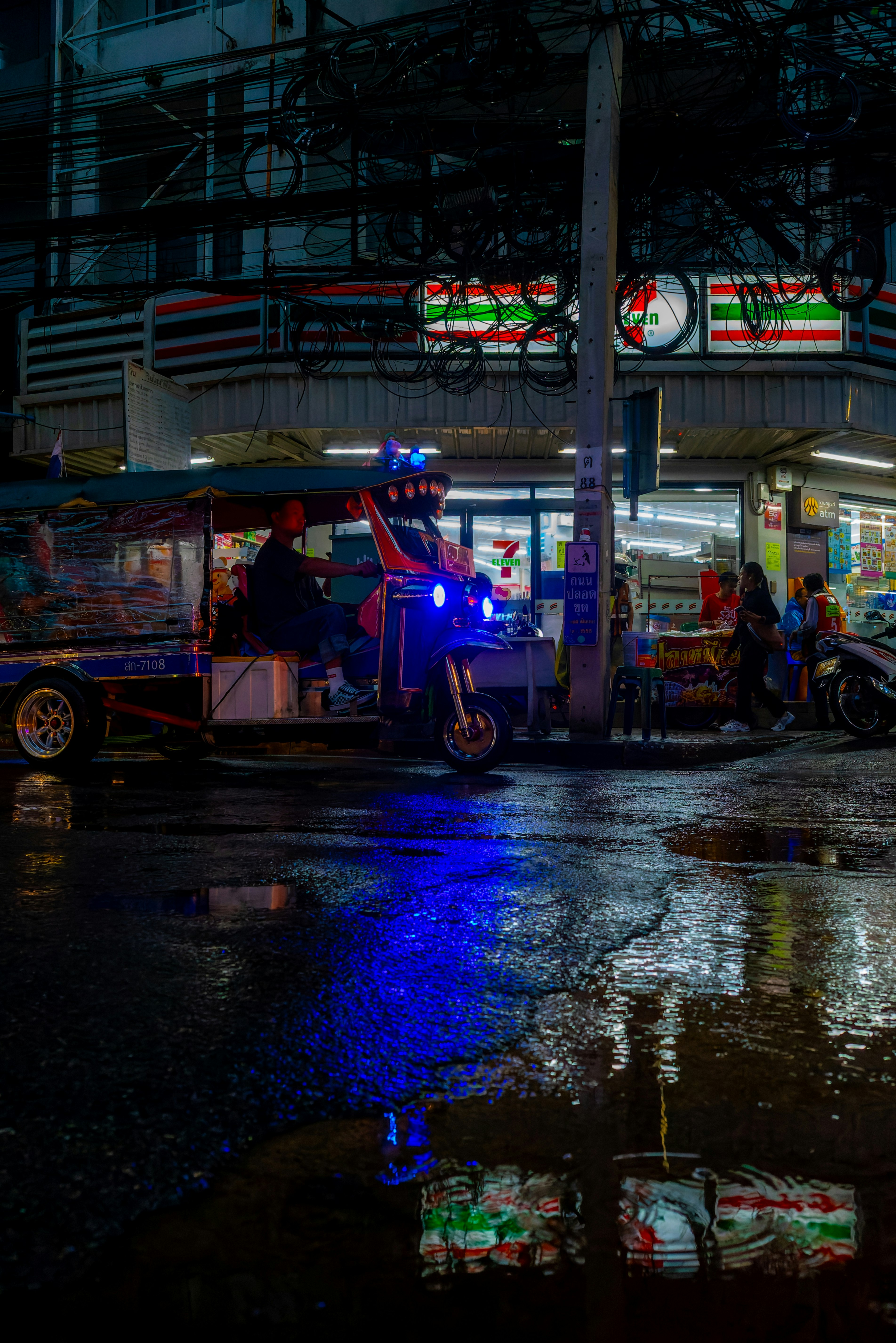 雨天街角的三輪車和霓虹燈招牌
