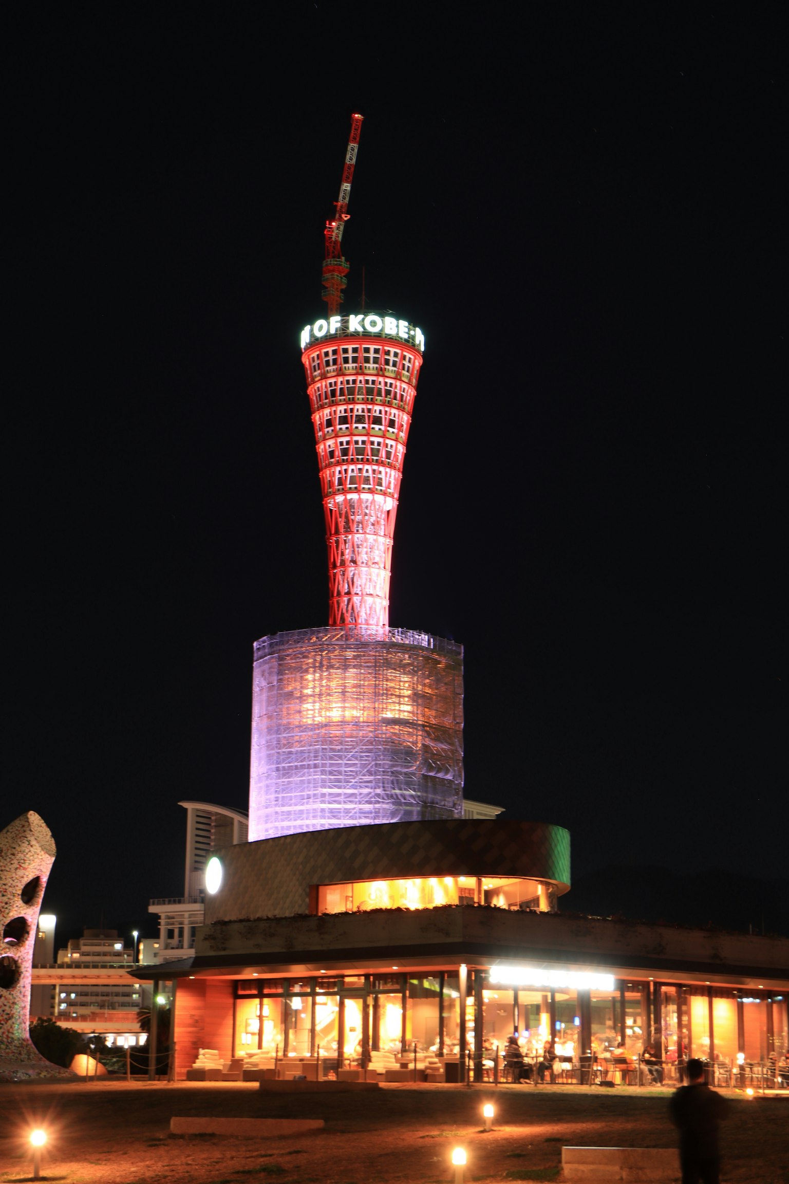 Torre portuale di Kobe splendidamente illuminata di notte con edifici circostanti