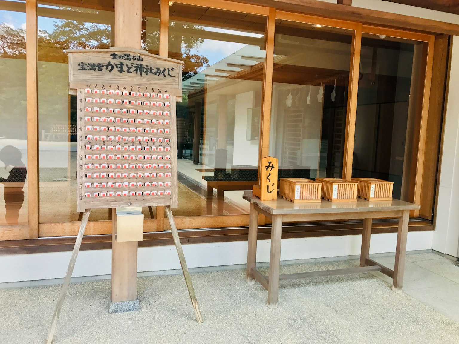 Una mesa de madera con pequeñas cajas y un tablero de ema en un santuario japonés