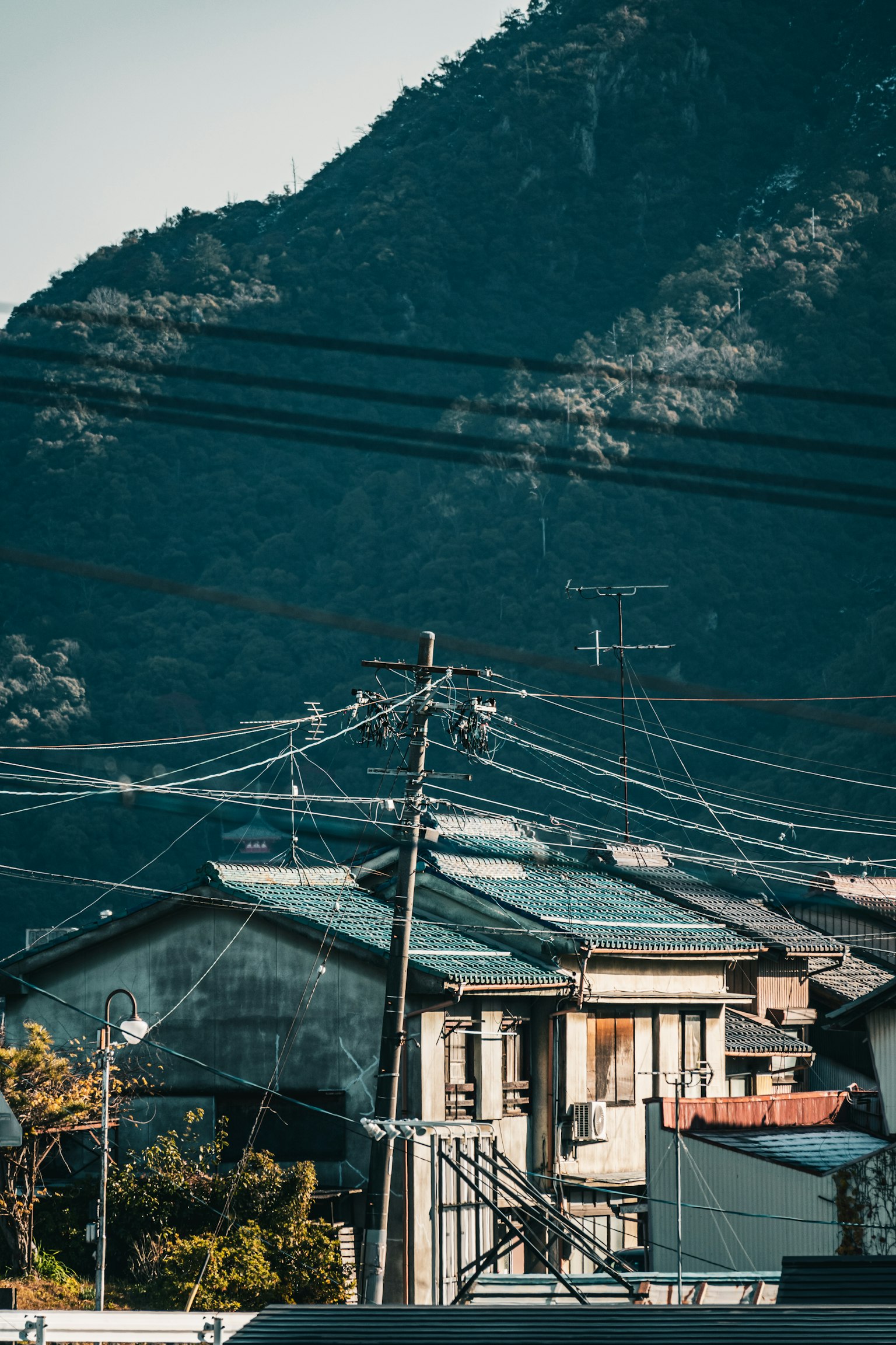전경에 전선과 집이 있는 배경에 산이 있는 풍경