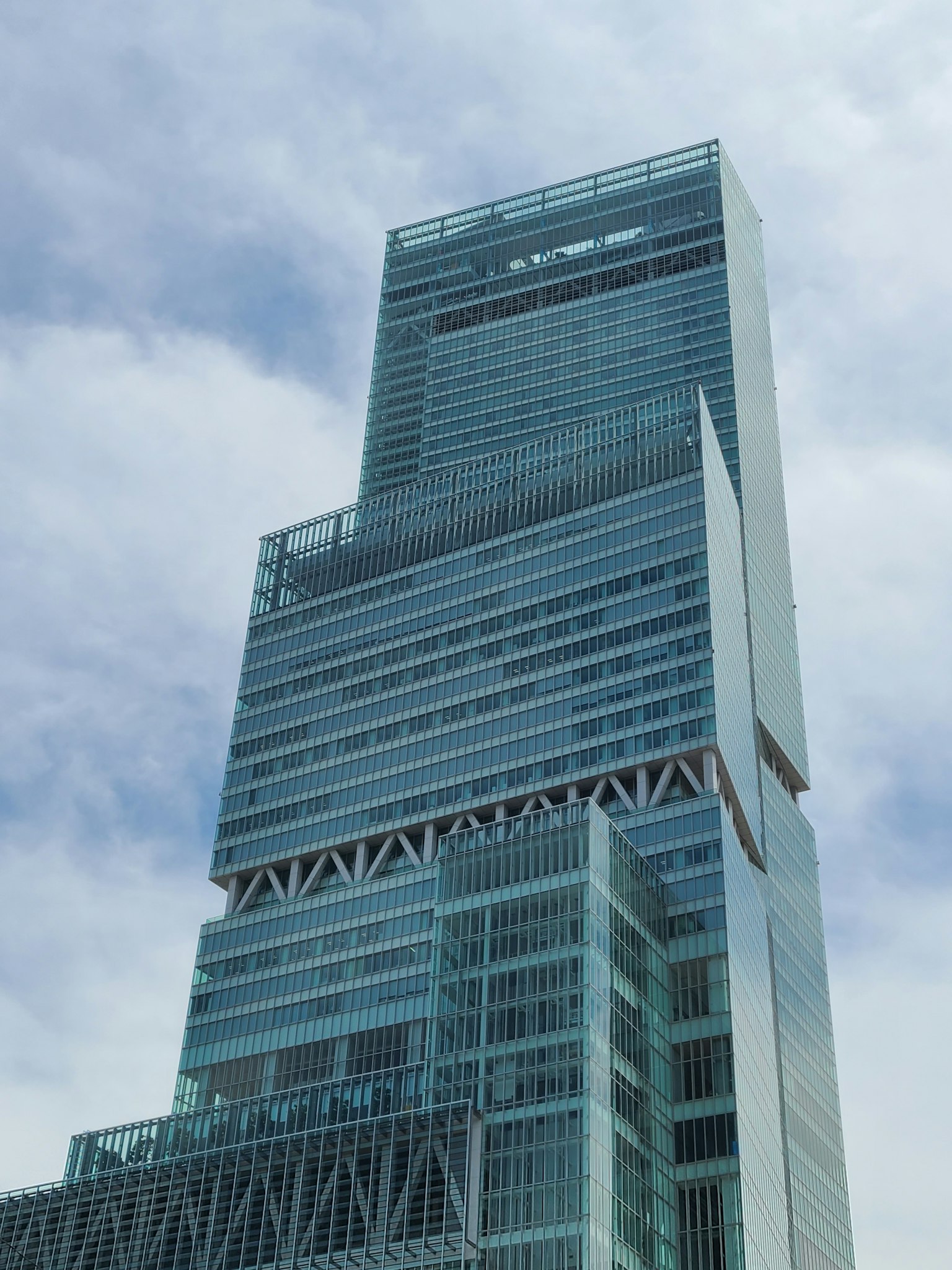 Close-up of a skyscraper with a glass facade modern design soaring under a blue sky