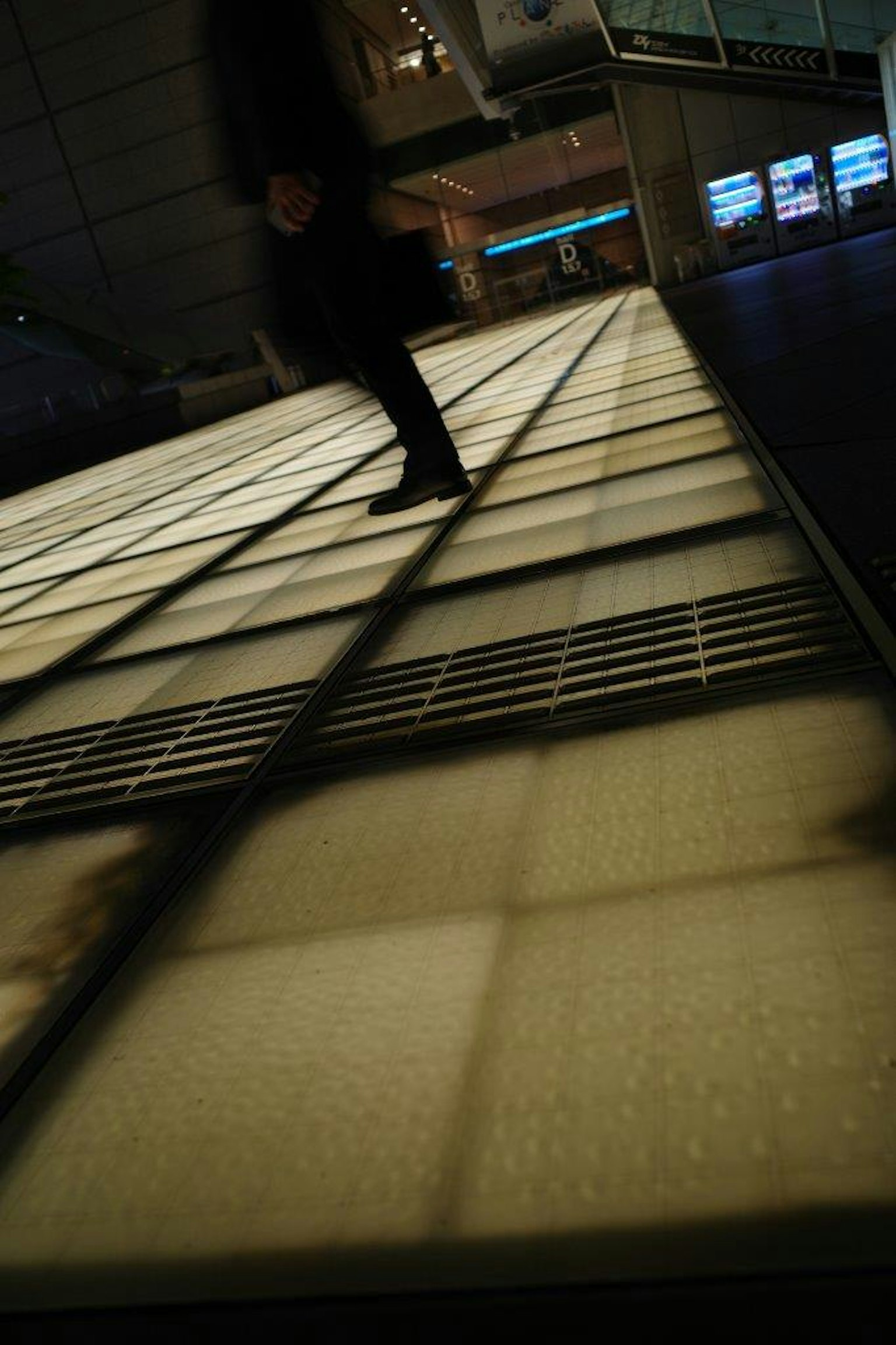 Silhouette d'une personne marchant sur un sol lumineux