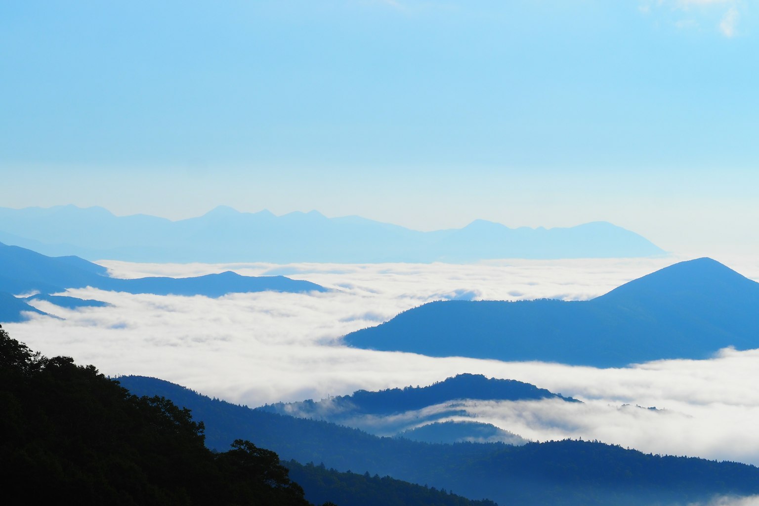 蓝天下被云海环绕的山脉风景