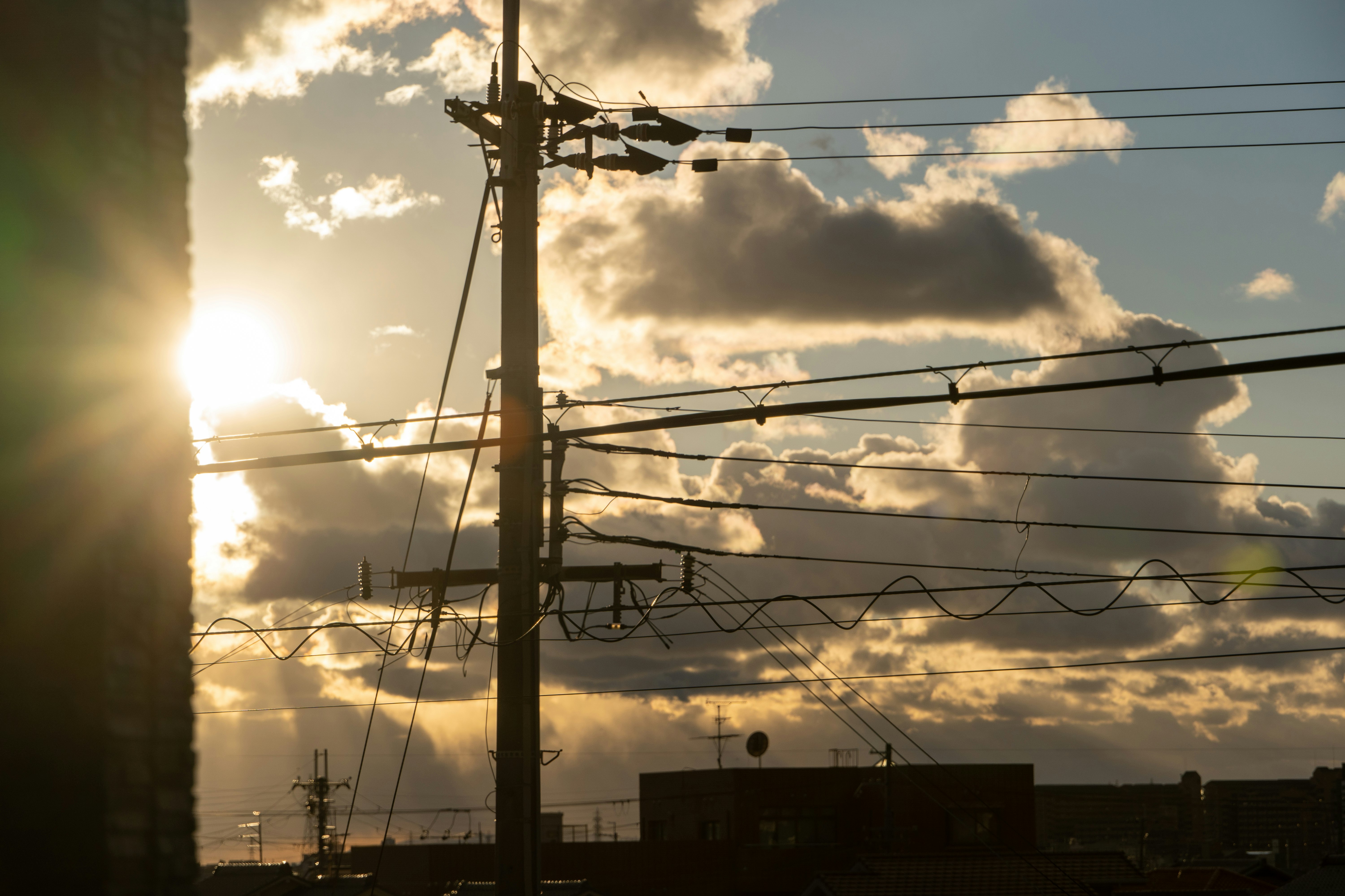 Sunset-lit power lines and utility poles over an industrial sky