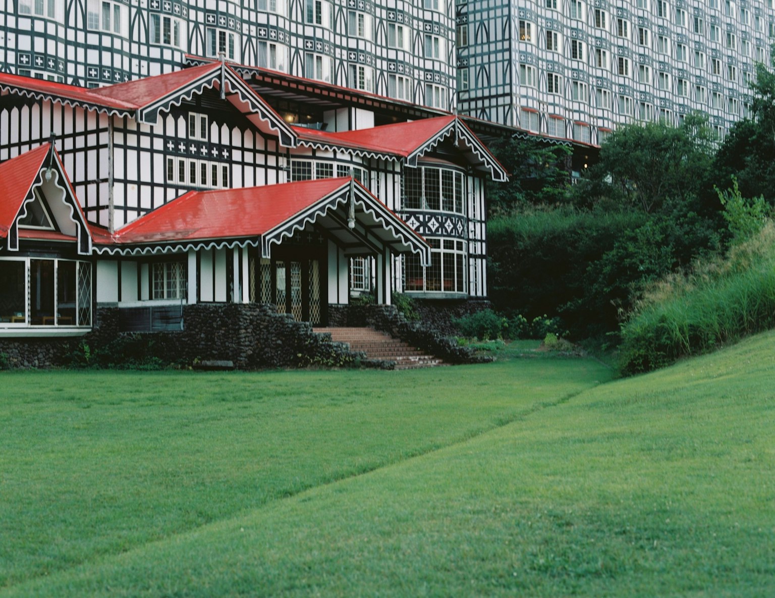 赤い屋根の伝統的な建物と現代的な高層ビルが並ぶ風景