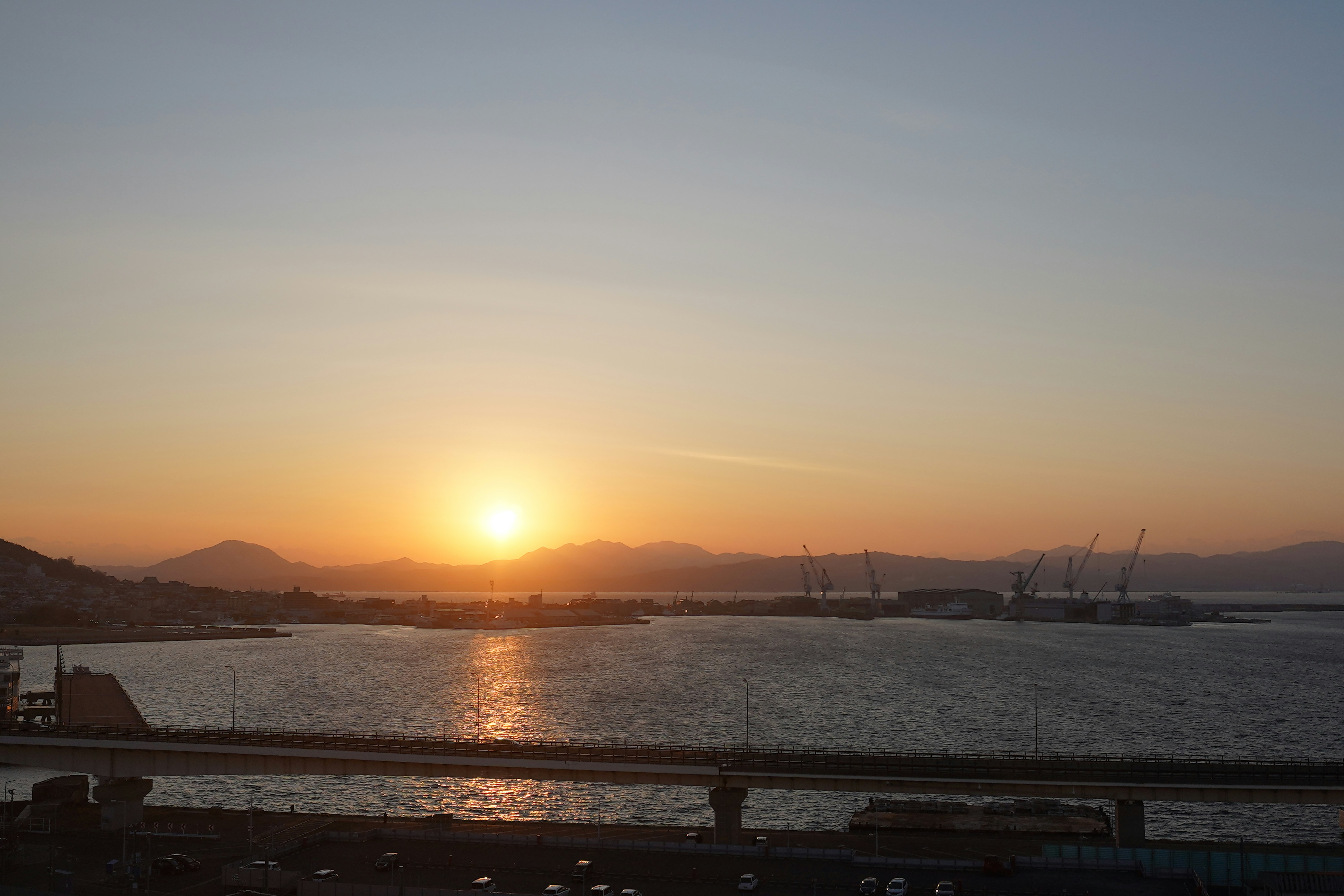 夕日に照らされる港の海と橋の風景