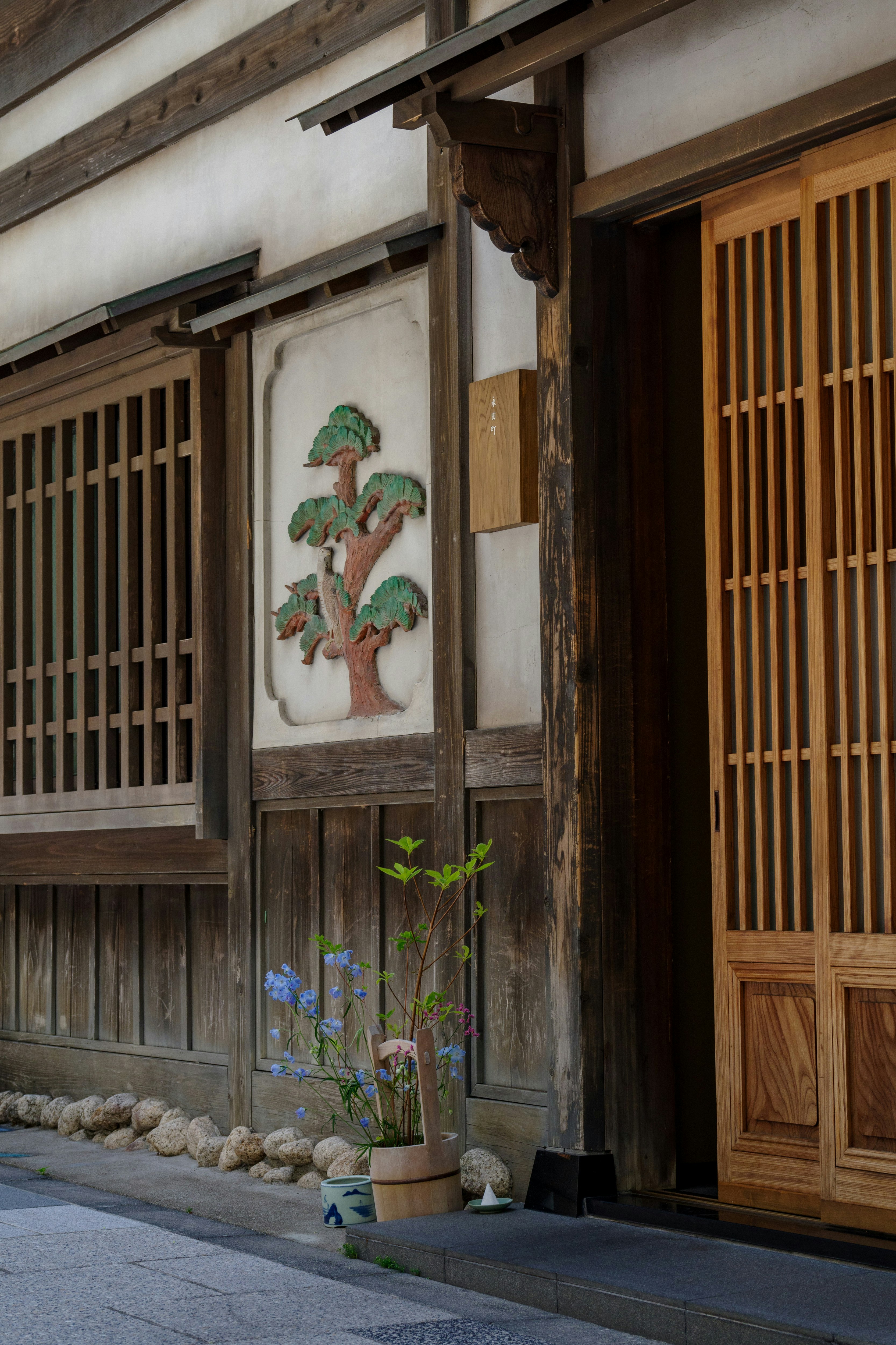 Japanese storefront with ikebana in a hand bucket