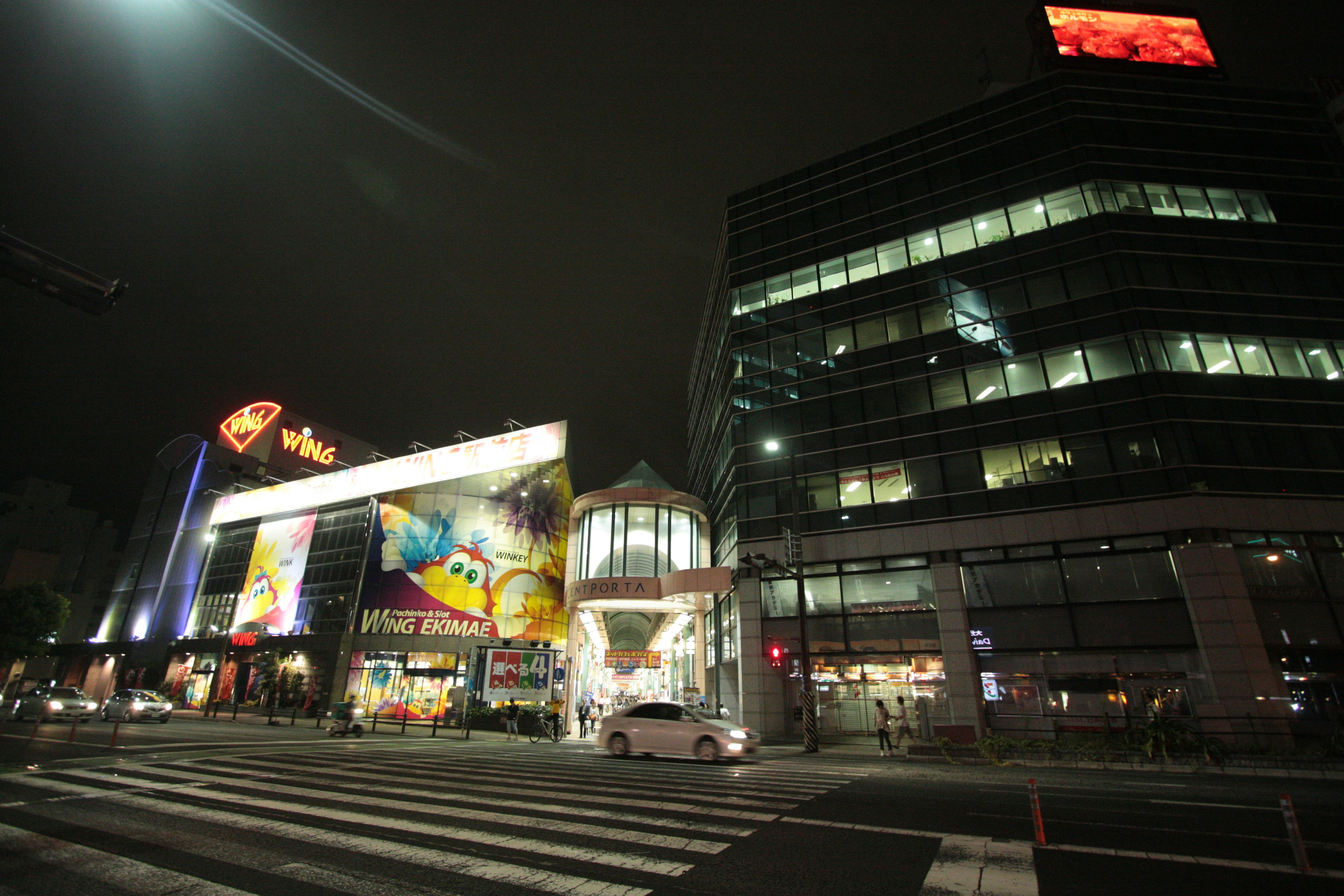 夜の交差点と大型ビル、ネオン看板のある繁華街の街並み