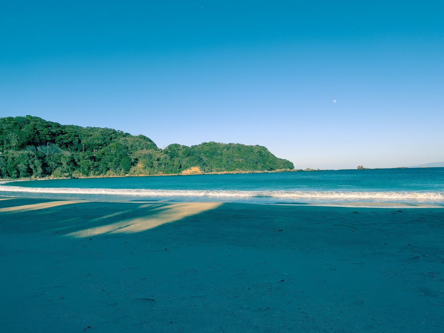Vue de plage pittoresque avec océan bleu et collines verdoyantes