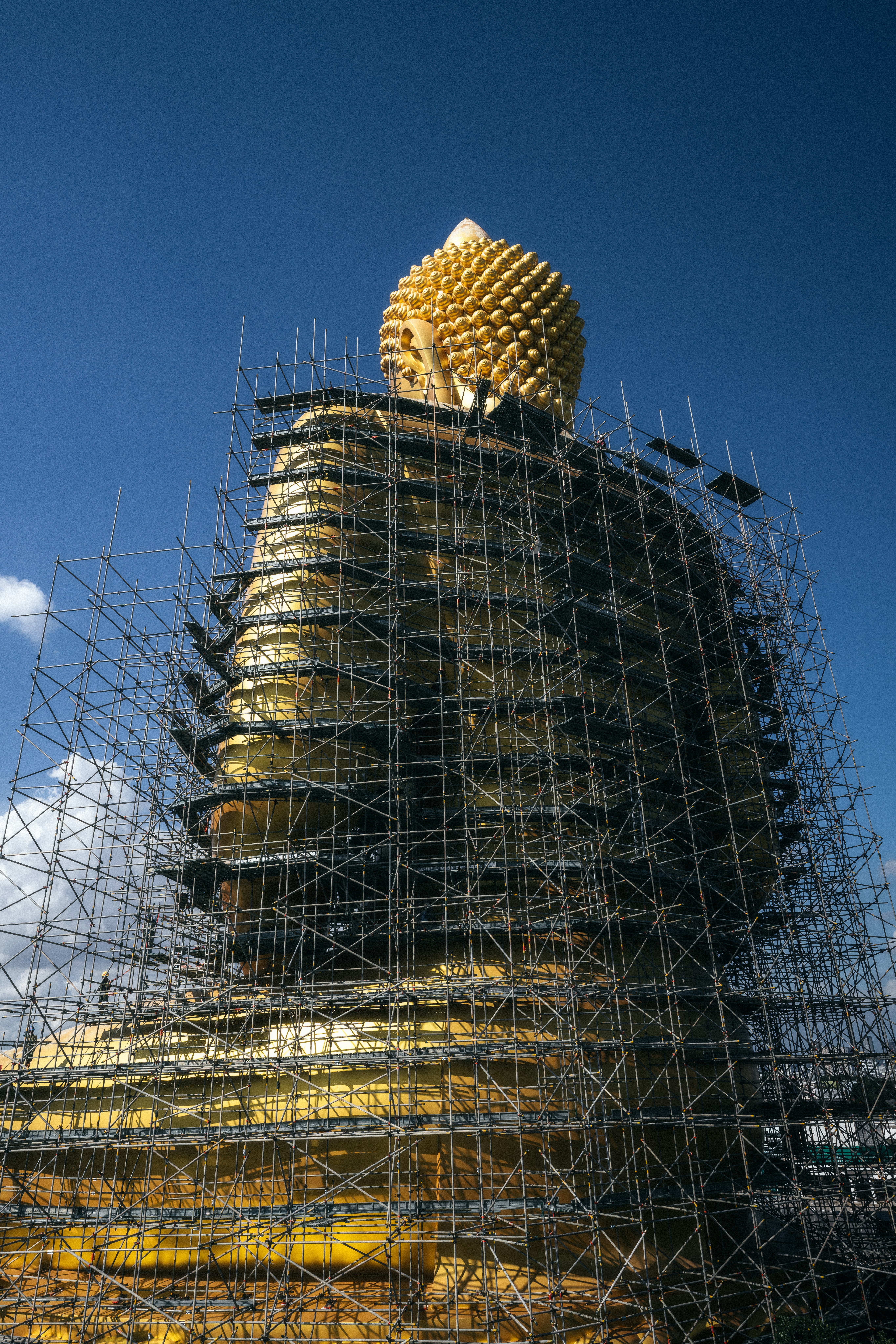 クレーンと足場に囲まれた建設中の大規模建物の外観