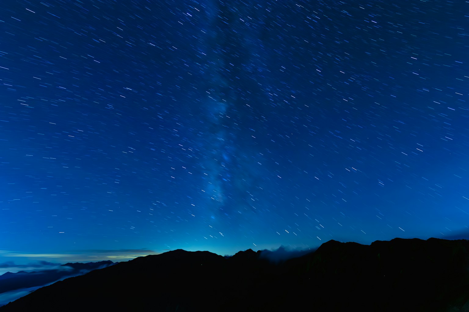 Vue pittoresque d'un ciel étoilé avec la Voie lactée au-dessus des montagnes la nuit
