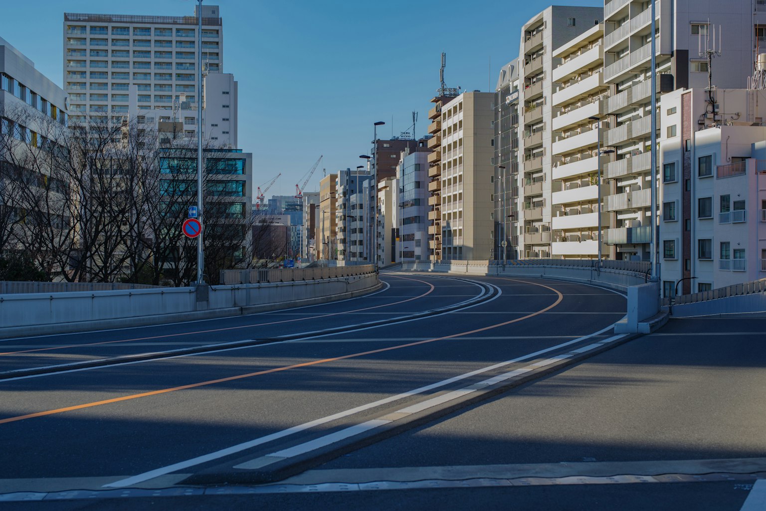 Kurvenstraße mit Gebäuden unter einem klaren blauen Himmel