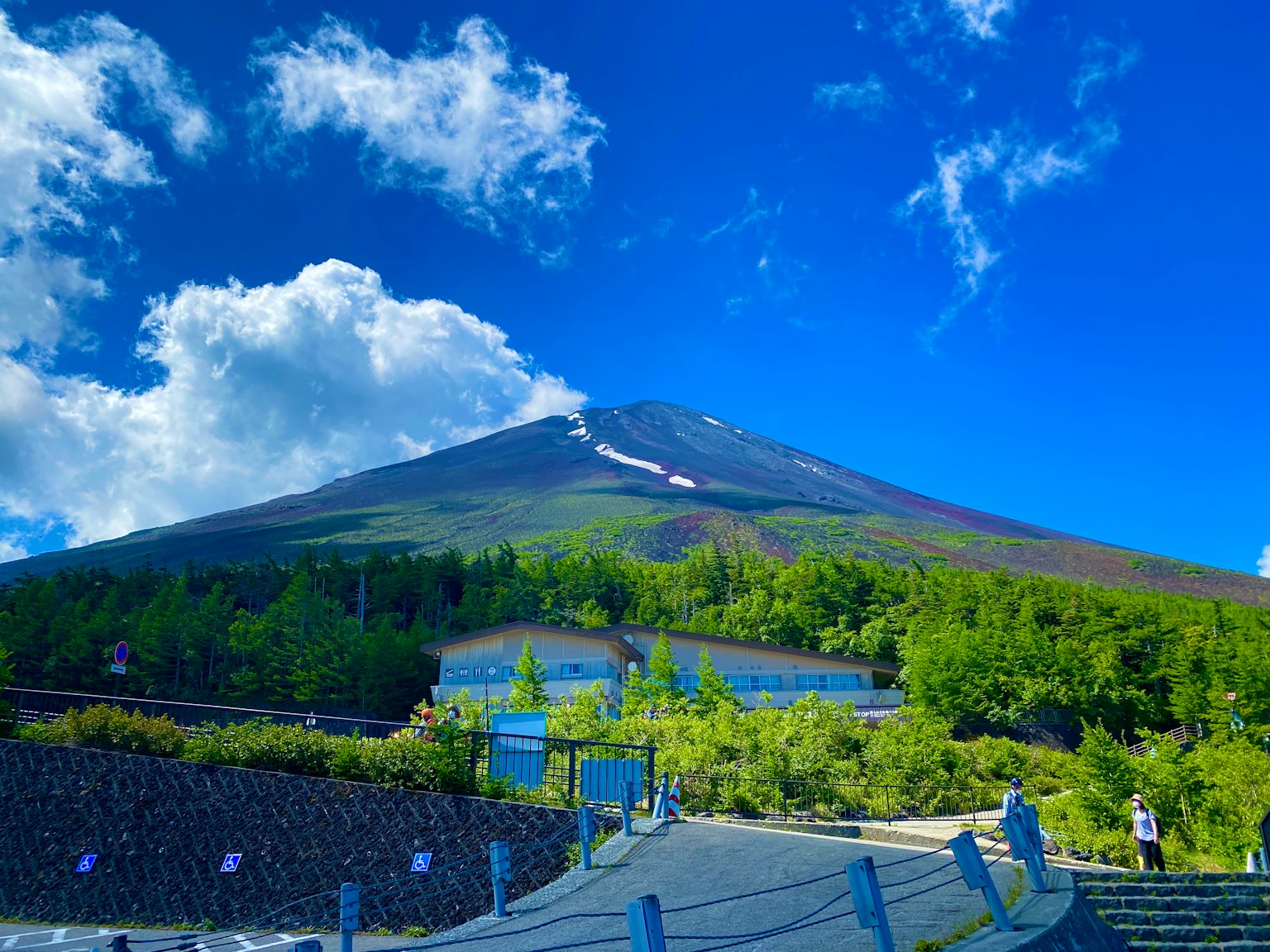 วิวที่สวยงามของภูเขาฟูจิพร้อมทิวทัศน์สีเขียวชอุ่มใต้ท้องฟ้าสีฟ้า