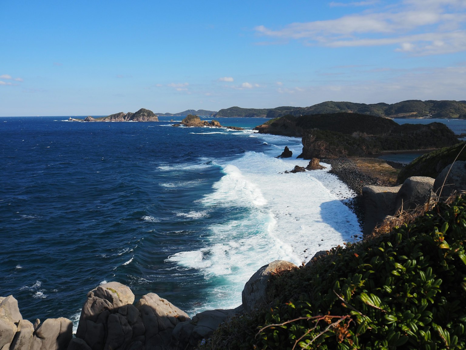Pemandangan pantai dengan lautan biru dan ombak putih