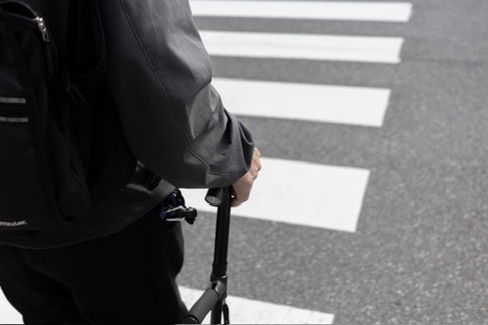 hands pushing a stroller at a crosswalk