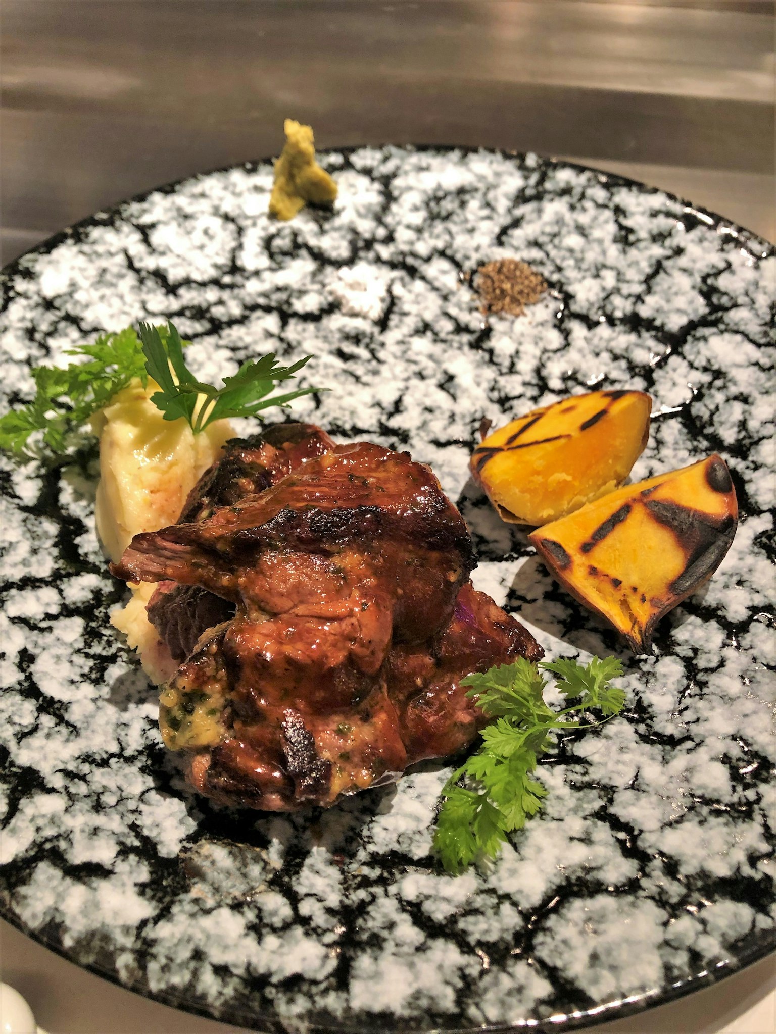 Viande grillée avec des légumes rôtis sur une assiette noire